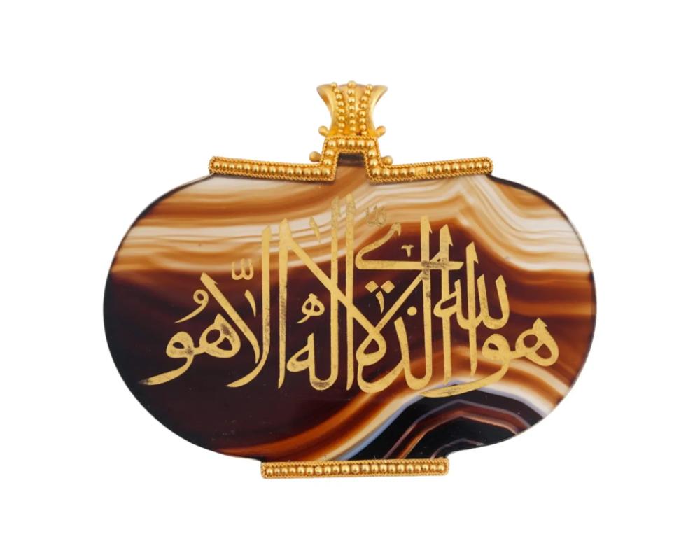 Un ciondolo in oro 22K e agata scolpita a mano. Il ciondolo è ornato da un dipinto artistico calligrafico scritto in lettere arabe dorate. Non segnato. Gioielli e accessori islamici arabi d'epoca e moderni in oro e pietre semipreziose per
