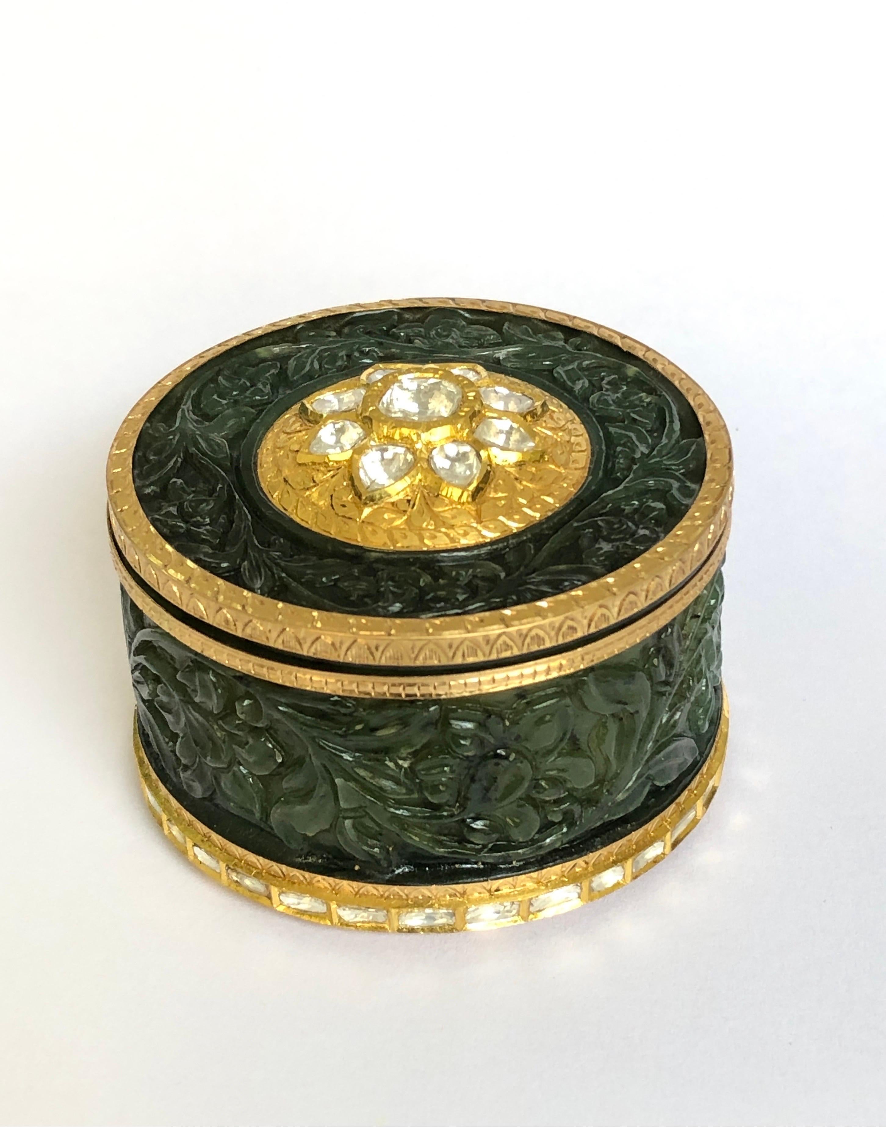 Finely carved nephrite jade snuff box carved with fine floral carvings. The box is set with the help of 22 and 24K solid pure gold, the gold frame is finely etched with painstaking art format of chilai which finds it birth in early 19th century. The