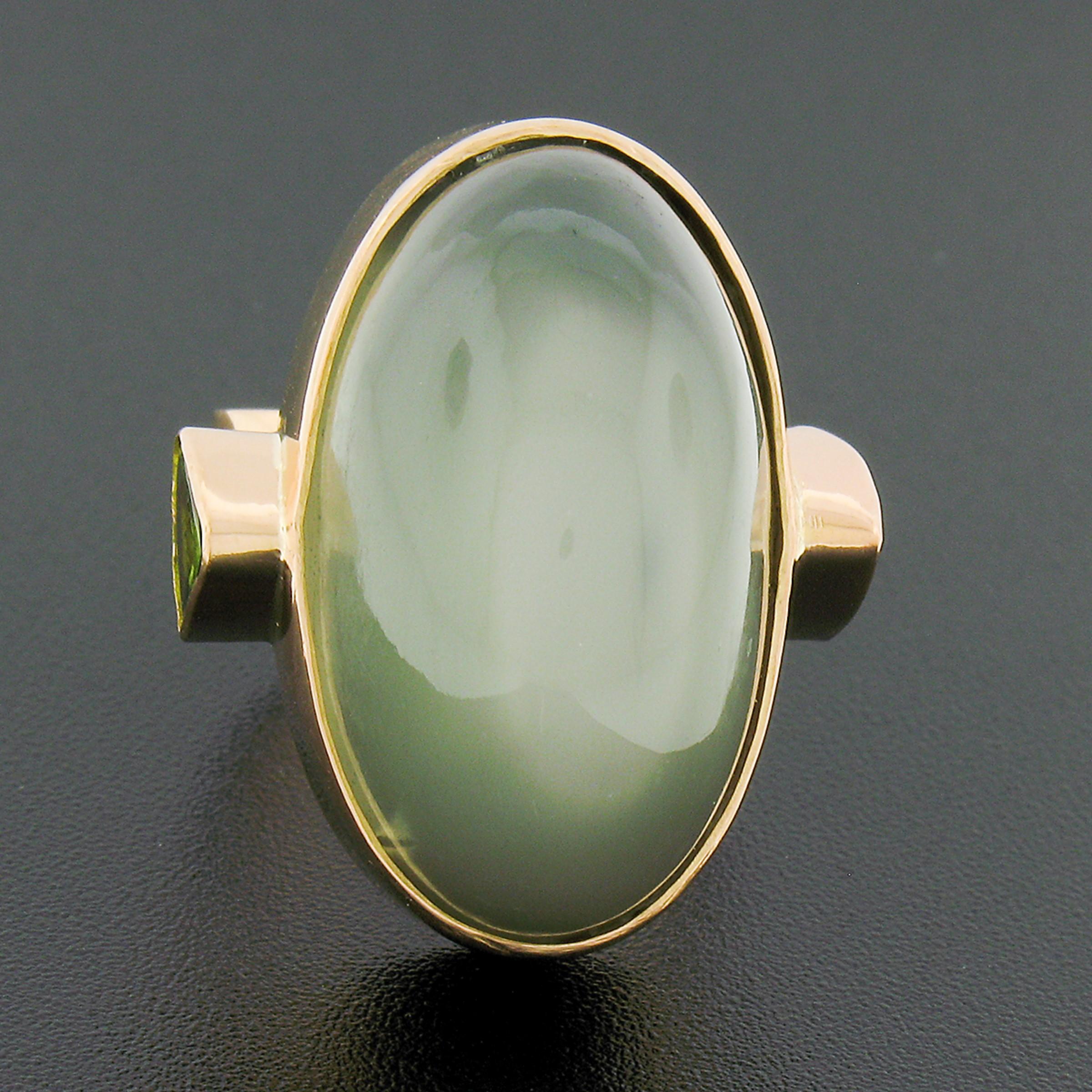 Here we have a truly bold vintage cocktail ring crafted in solid 22k rose gold and features a large, GIA certified, oval cabochon cut cat's-eye moonstone neatly bezel set at the center. The solitaire has a beautiful grayish-green base color that