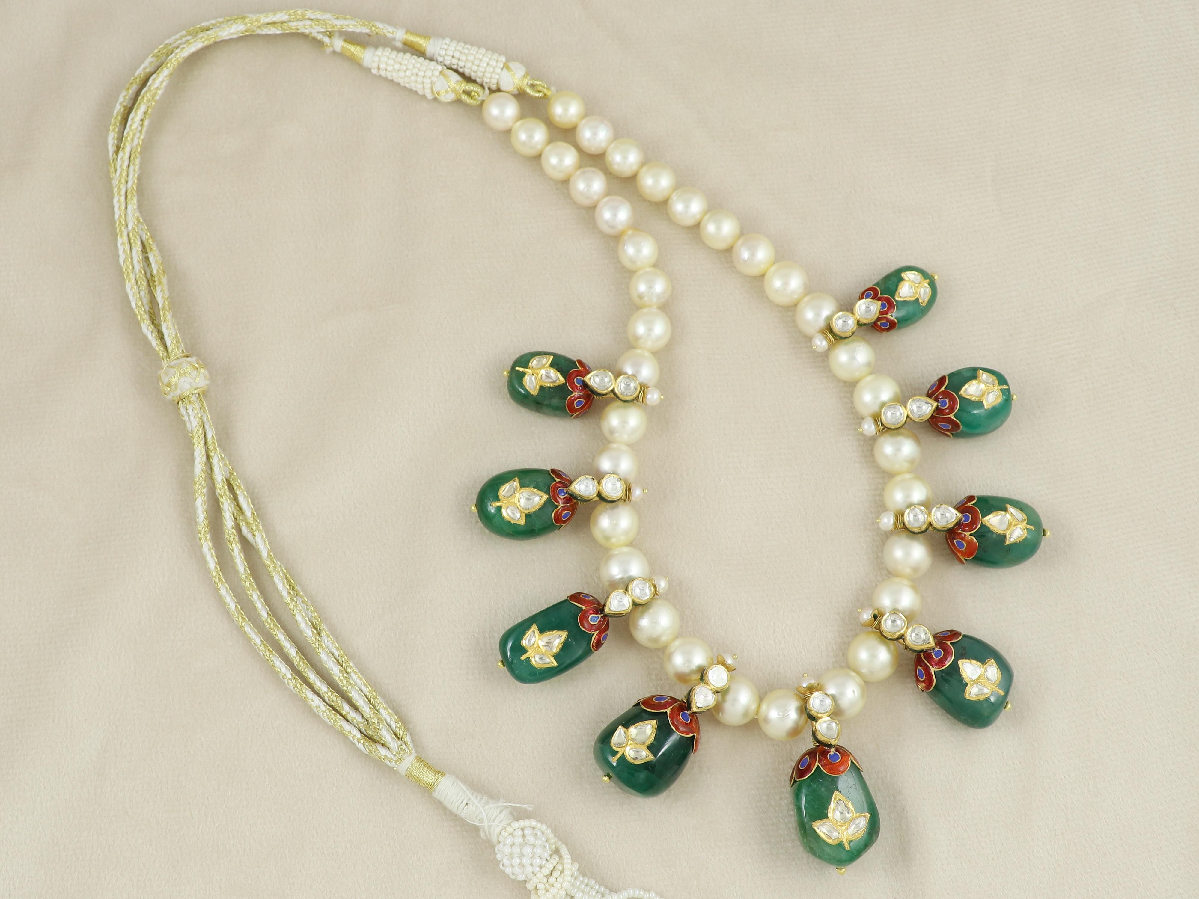 Una collezione di 9 burattini di smeraldo tutti intarsiati con un motivo a forma di fiore al centro con polacchi di diamanti non tagliati e oro 24 carati, sospesi con cappucci in oro rosso 22 carati con diamanti naturali non tagliati e fili di perle