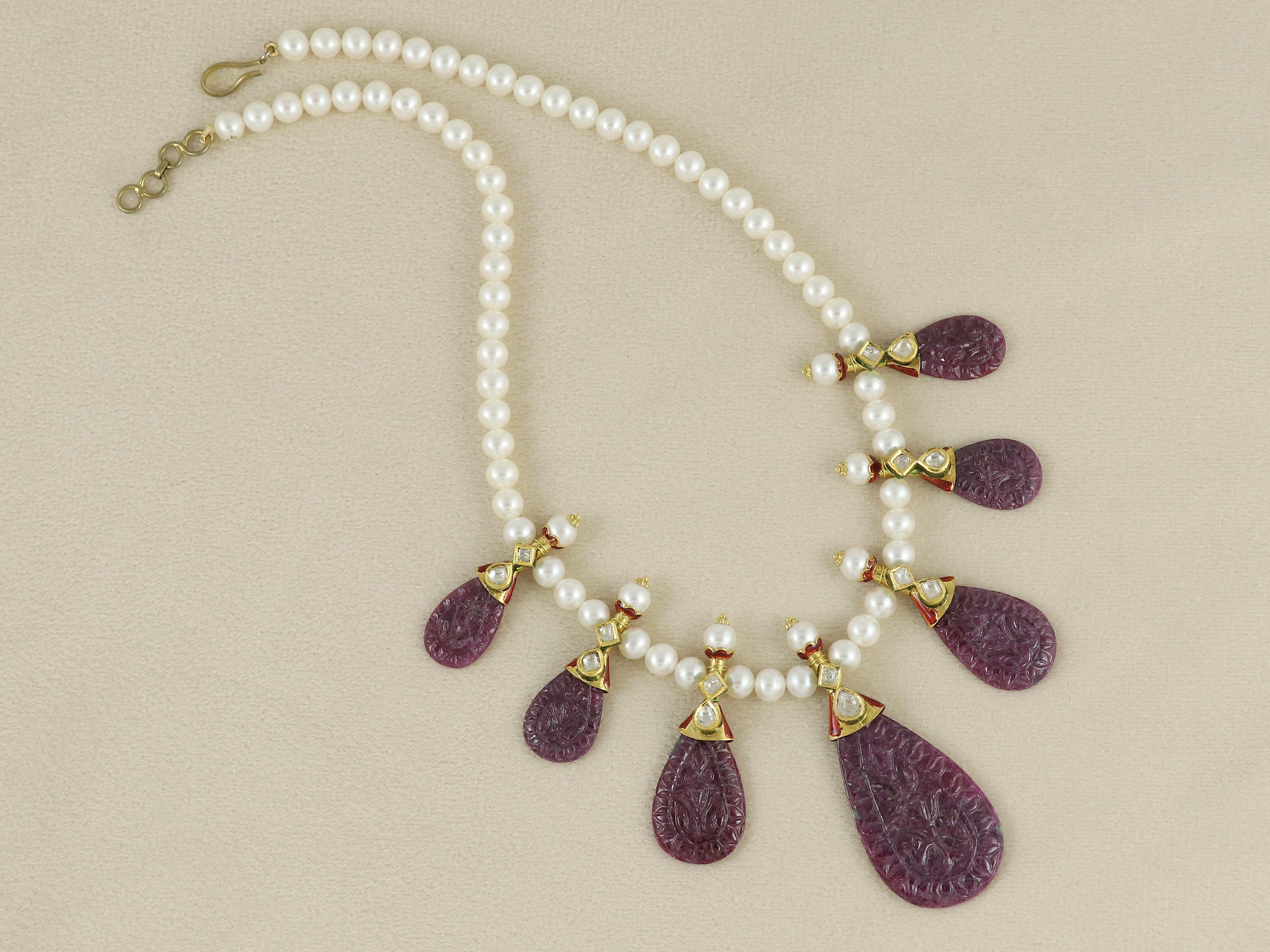 This finely handcrafted necklace is a refined expression of traditional Indian Kundan jewellery. Cast in 22K gold, the design features two glinting diamond Polkis, set in classic Kundan-style bezels, anchoring a beautifully hand-carved natural ruby