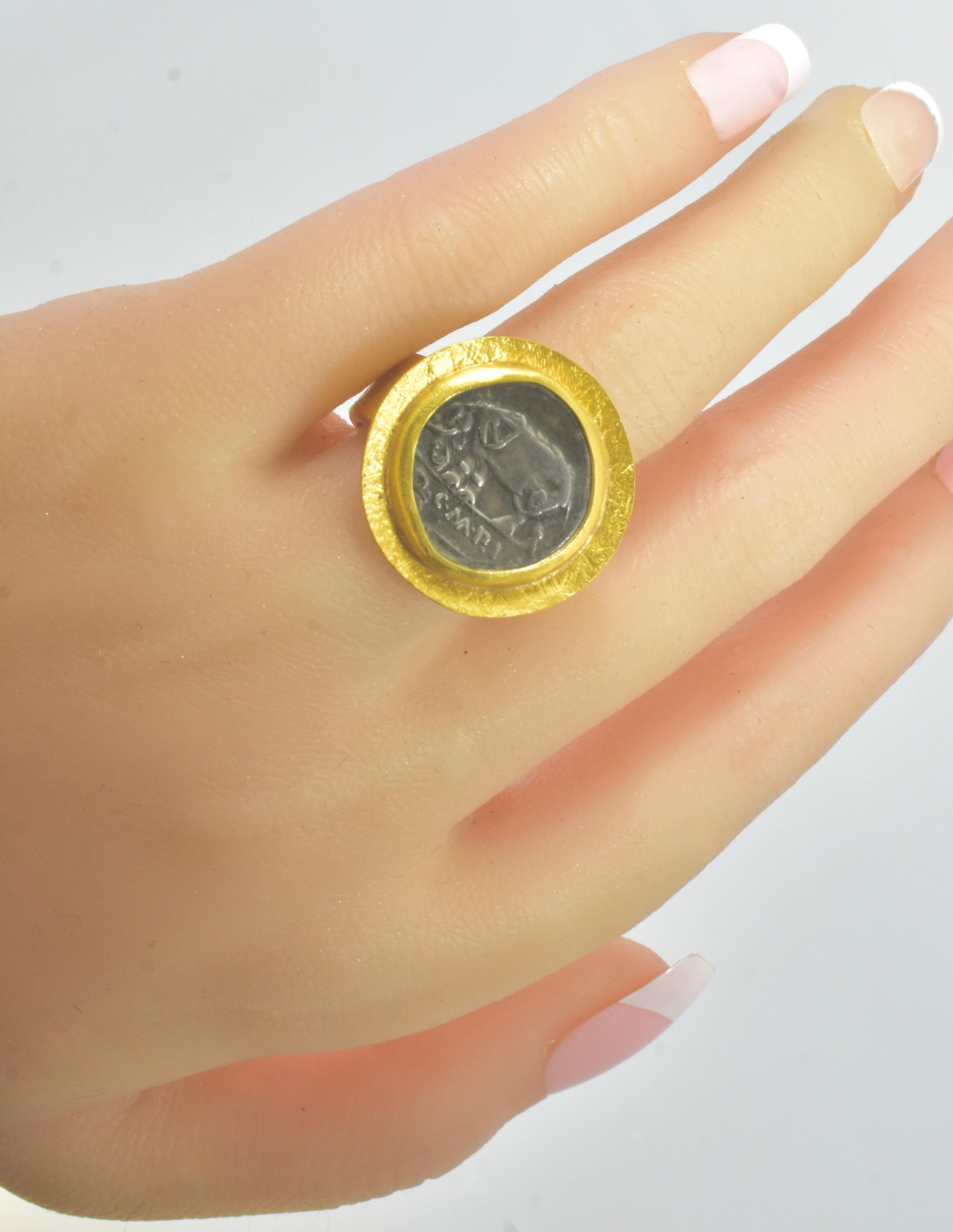 Sold as a lot the following:

1. Ancient Denarius, Coin of Quintus Caecilius Metellus Pius, mounted in a 22K hand hammered, hand crafted large and stately gold ring by Fairchild & Co. The authentic Roman Denarius, approximately 17 mm., is in fine
