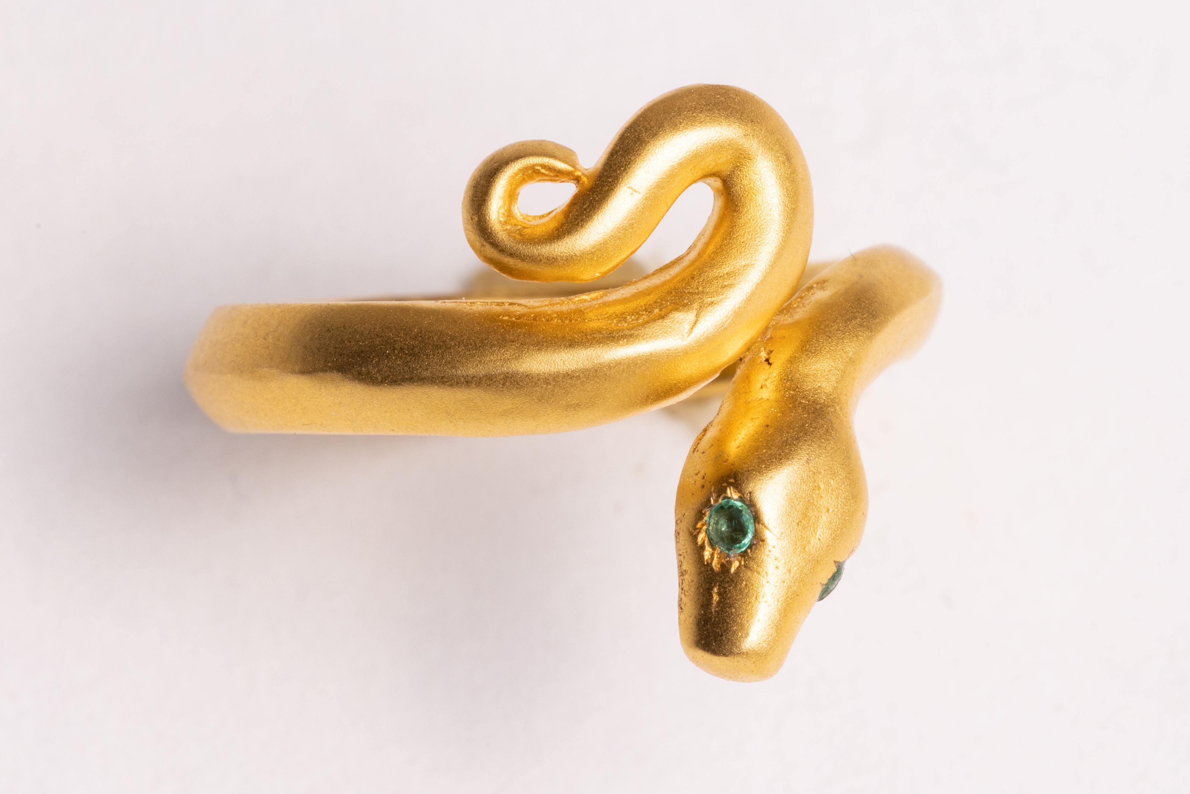 An appealing 22K gold matte finish, hand-crafted snake band ring.  It has round, faceted emerald eyes.  Size is 8.25.

The fine jewelry collection is sourced, designed or created by Deborah Lockhart Phillips. Through her international travels, she