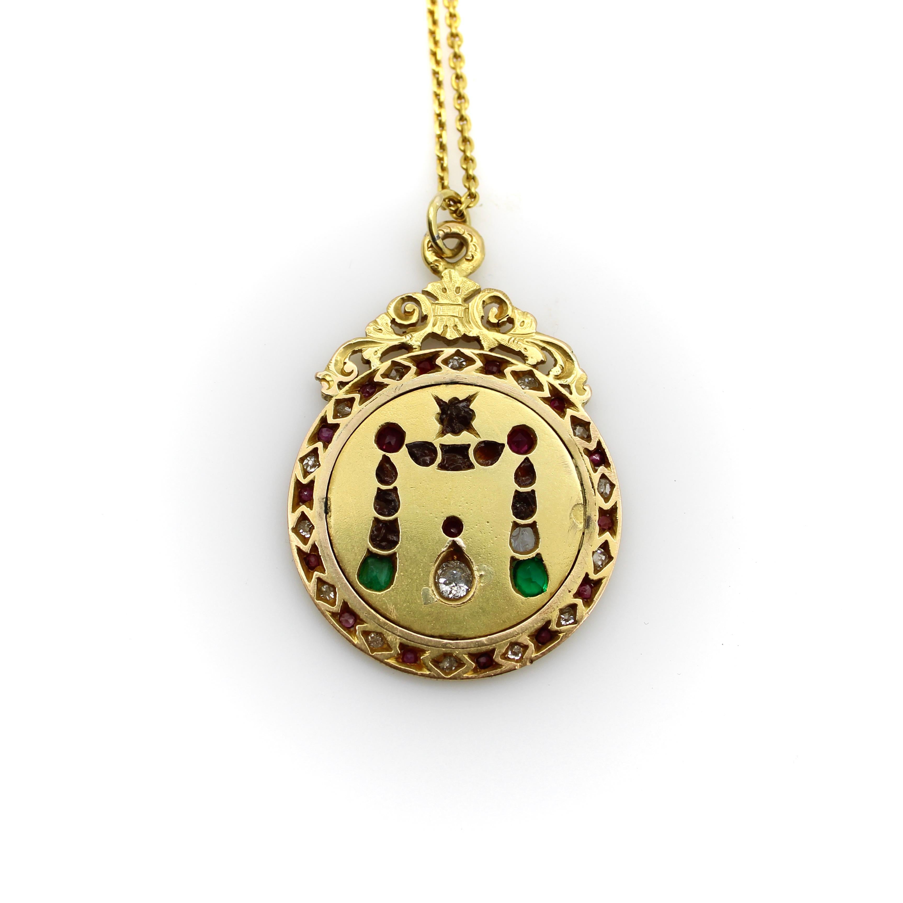 Circa 1840, this 22k gold medallion pendant is a treasure. Encrusted with colorful antique gemstones, the pendant contains a stunning array of hand cut diamonds, emeralds, and rubies. The pendant takes its shape from a coin, with a ribbed outside