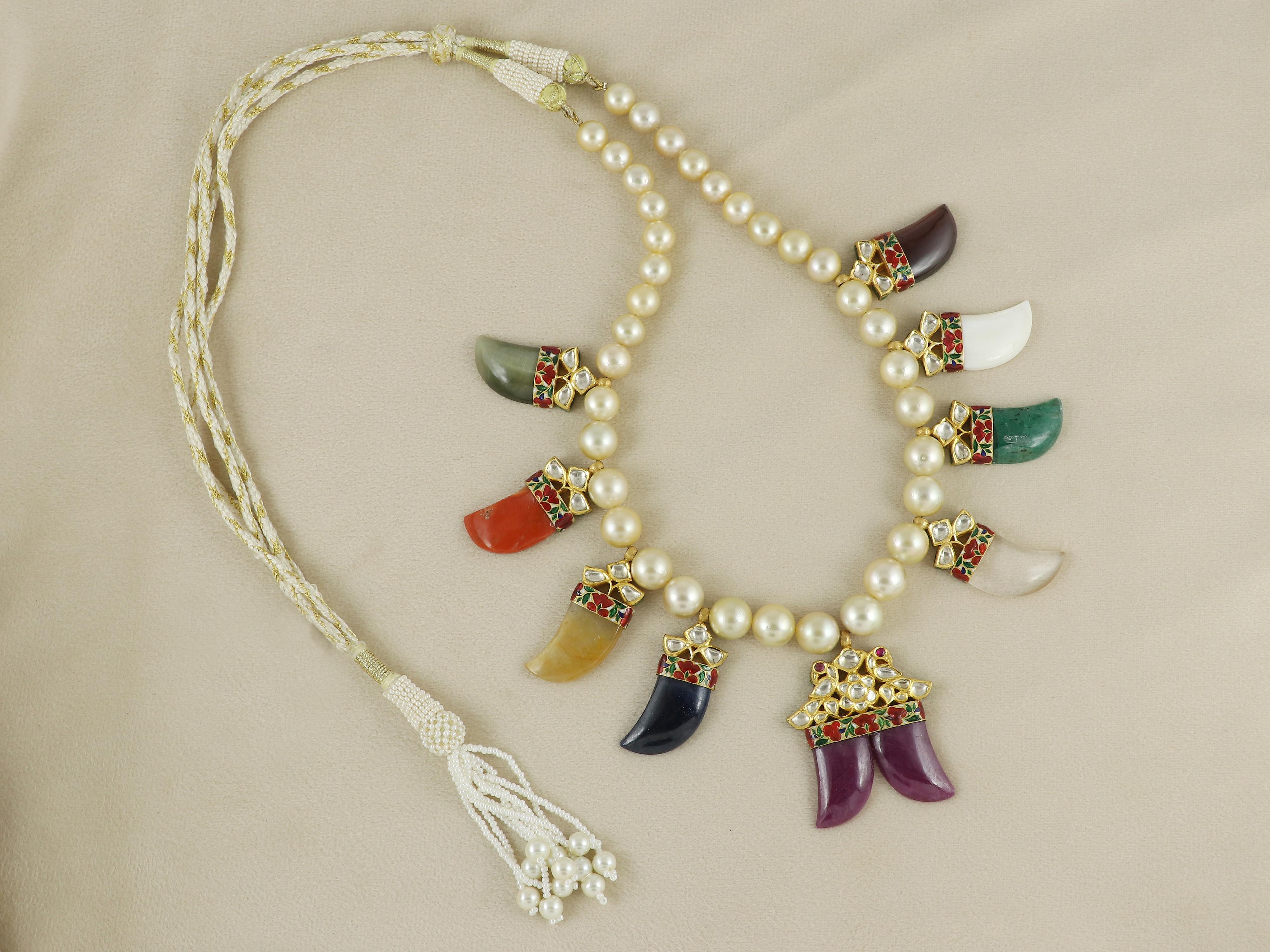 Diese opulente Navratna-Halskette ist eine Meisterleistung traditioneller indischer Handwerkskunst und zeigt die königliche Grandeur des Schmucks aus der Mogulzeit, neu interpretiert für den modernen Liebhaber. Die aus reinem 22-karätigem Gold