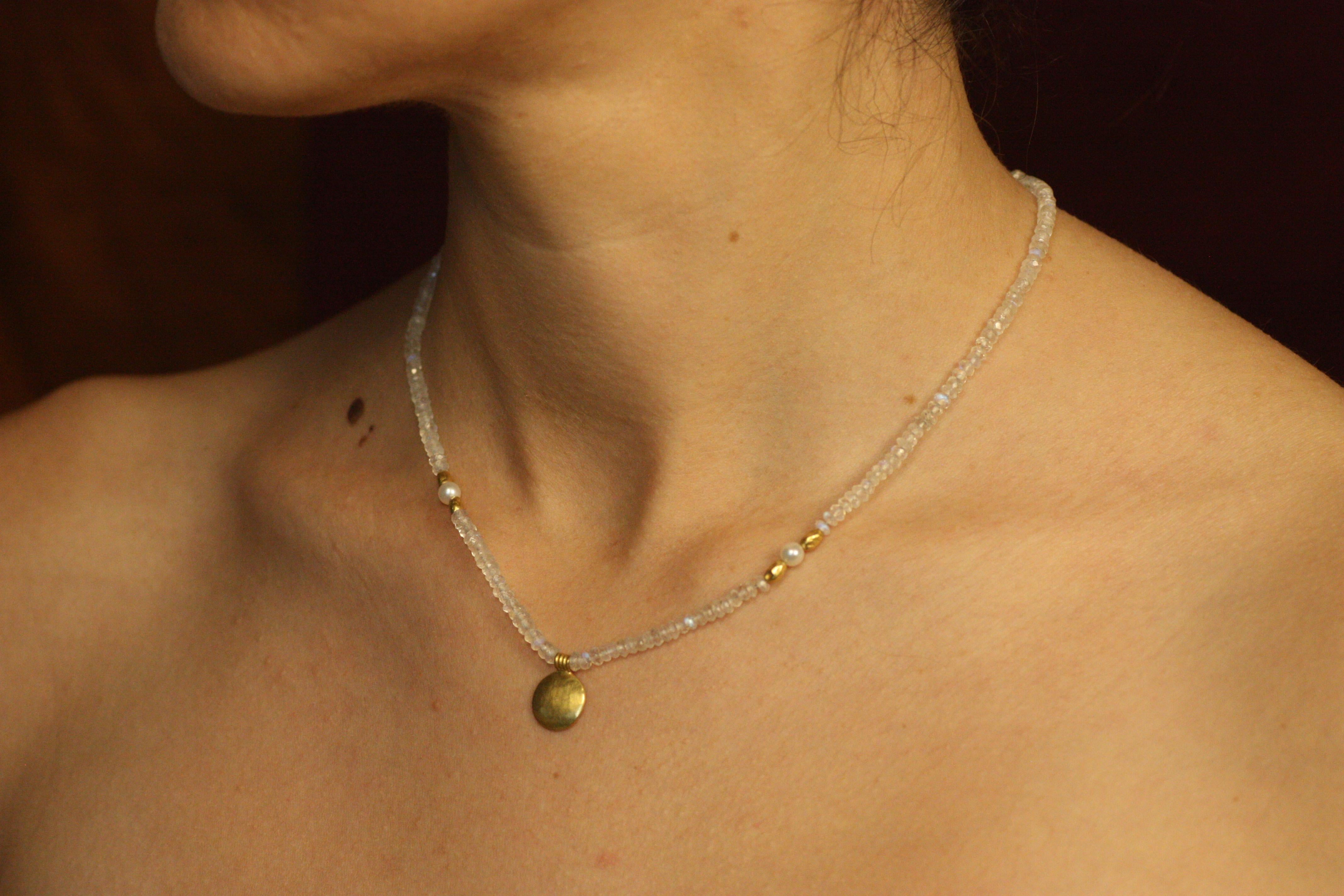 Drawing from the opulent allure of Egyptian Revival design, this one-of-a-kind Sun Disc Necklace captures the timeless splendor of a bygone era. Featuring 16 inches of luminous moonstone and radiant freshwater pearls, it is adorned with hand-forged