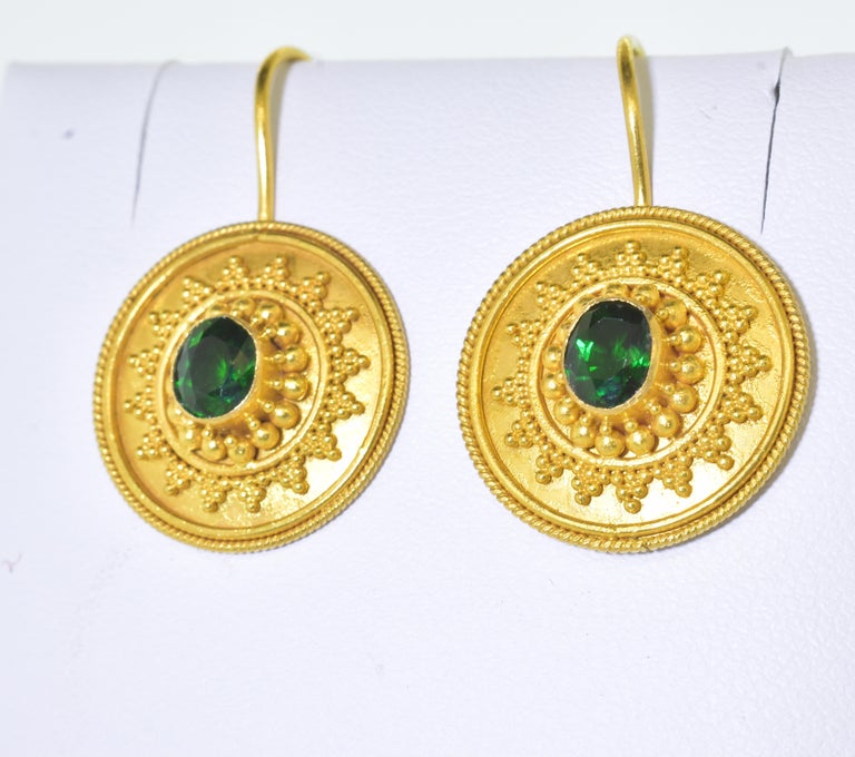 22K yellow gold and Chrome Tourmaline earrings hanging just below the ear.  These earrings have wonderful gold bead work surrounding the fine natural bright green Chrome Tourmalines.  There is an estimated weight of 1.6 cts. of fine bright, clean