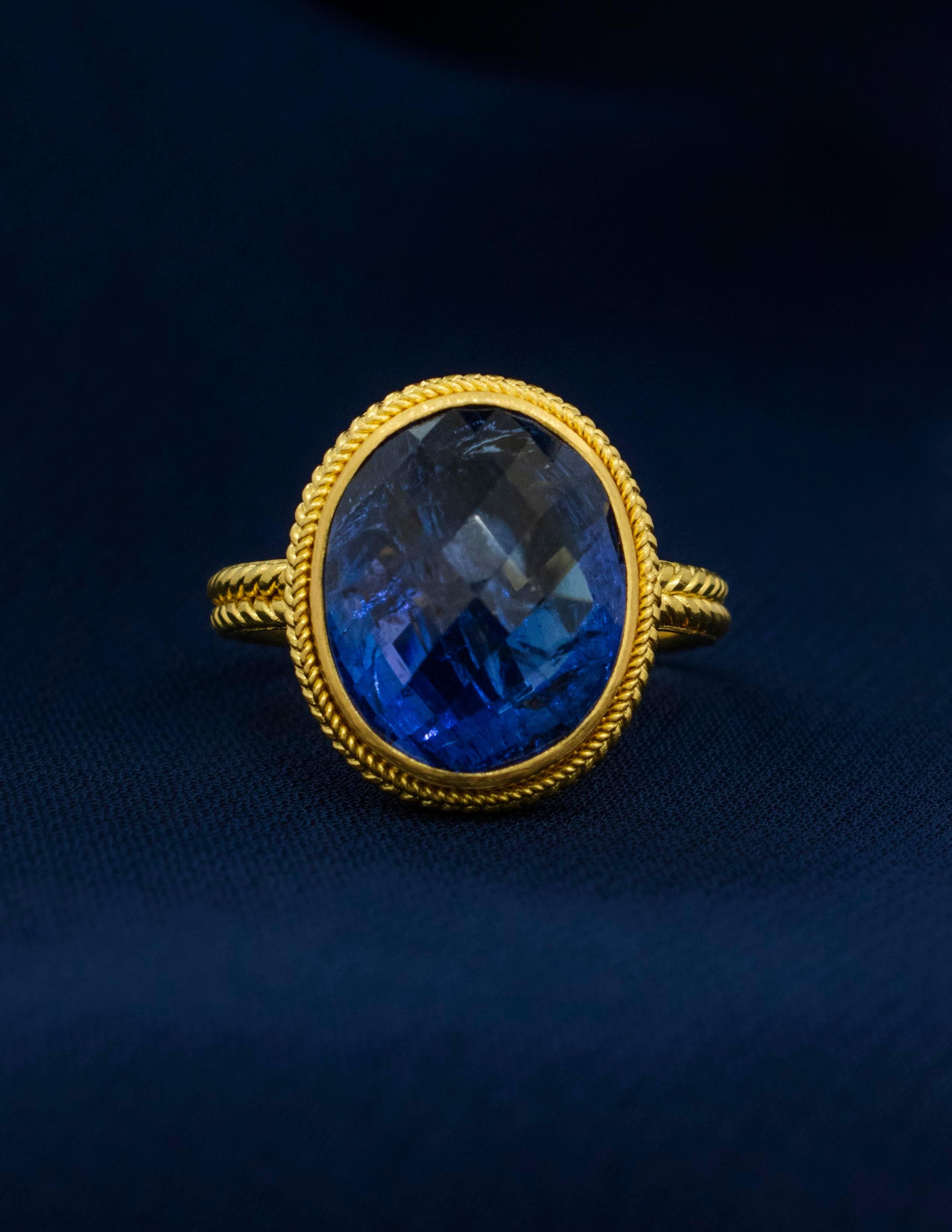 Este anillo bizantino de oro amarillo de 22 quilates es un excelente ejemplo de la antigua artesanía de convertir el oro puro en arte ponible. La elaboración y el detalle son impecables. 
La tanzanita facetada briolette ovalada es de un profundo