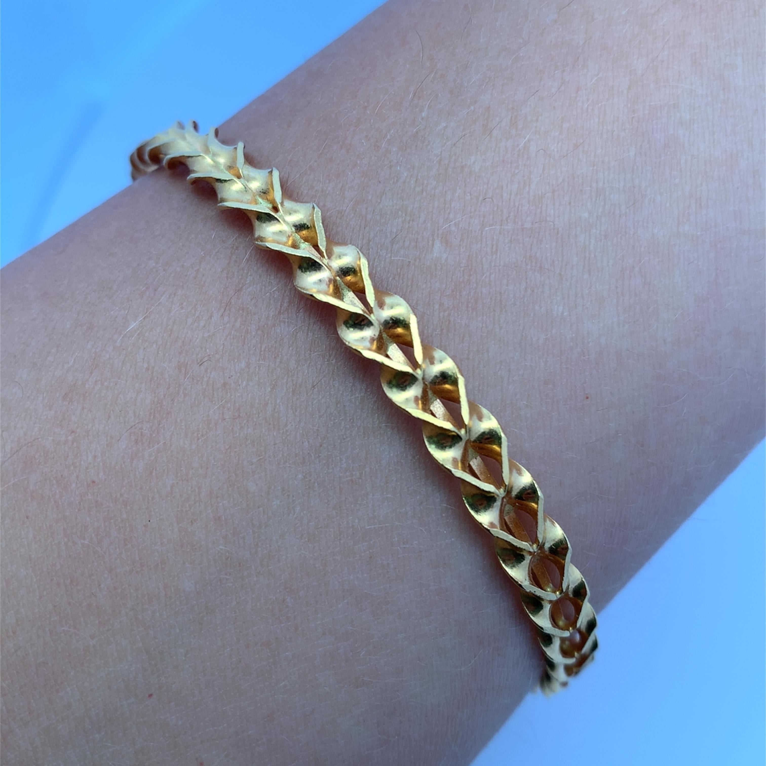 This elegant pure 22k yellow gold bangle showcases a meticulously crafted design. The continuous pattern offers a sleek and stylish aesthetic, perfect for adding a touch of sophistication to any ensemble. Its lightweight construction ensures