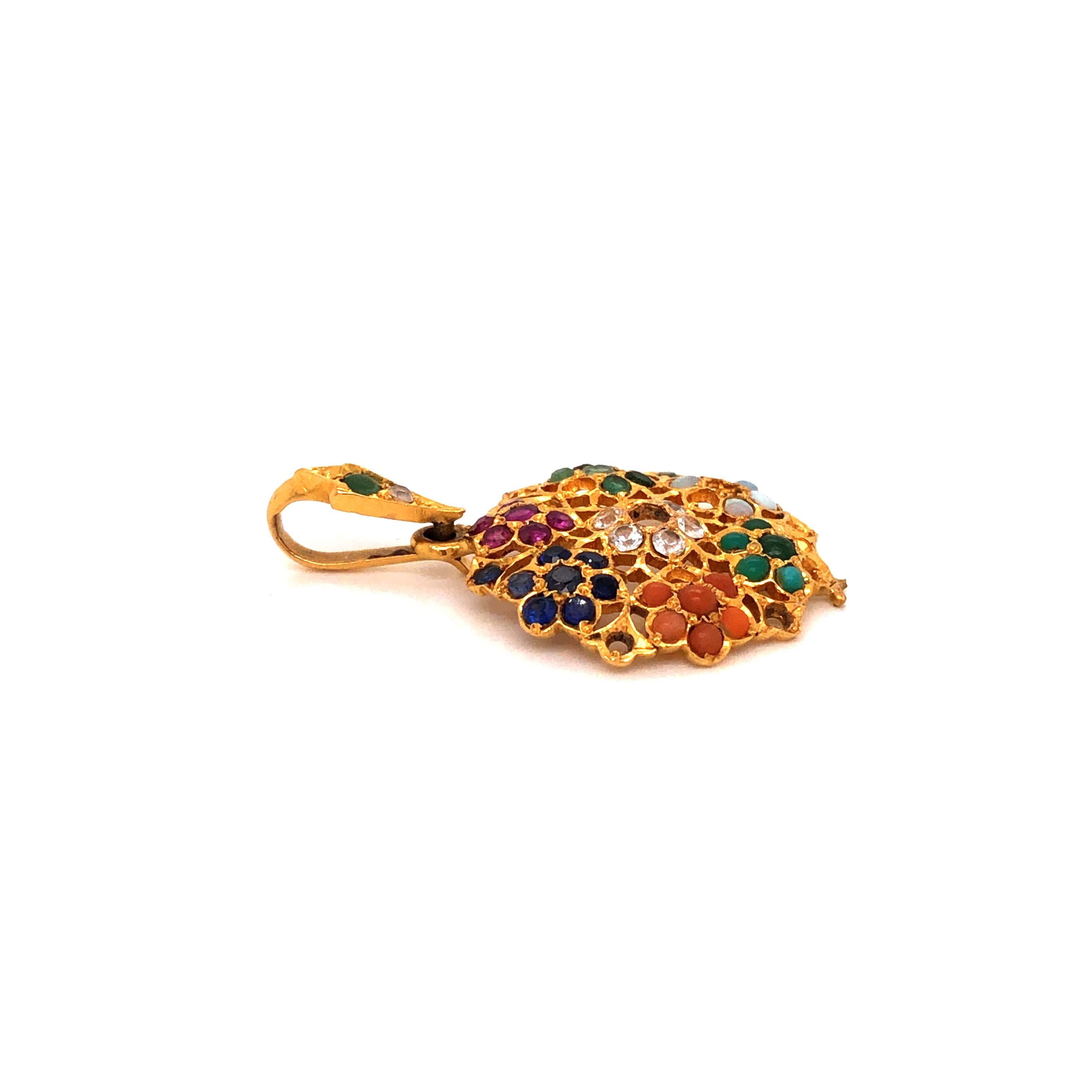 22K yellow gold pendant containing round emeralds, opals, rubies, blue and white sapphires, and turquoise.

Metal: 22K Yellow Gold

Size: 21mm x 34mm

Total Weight: 3.6 grams