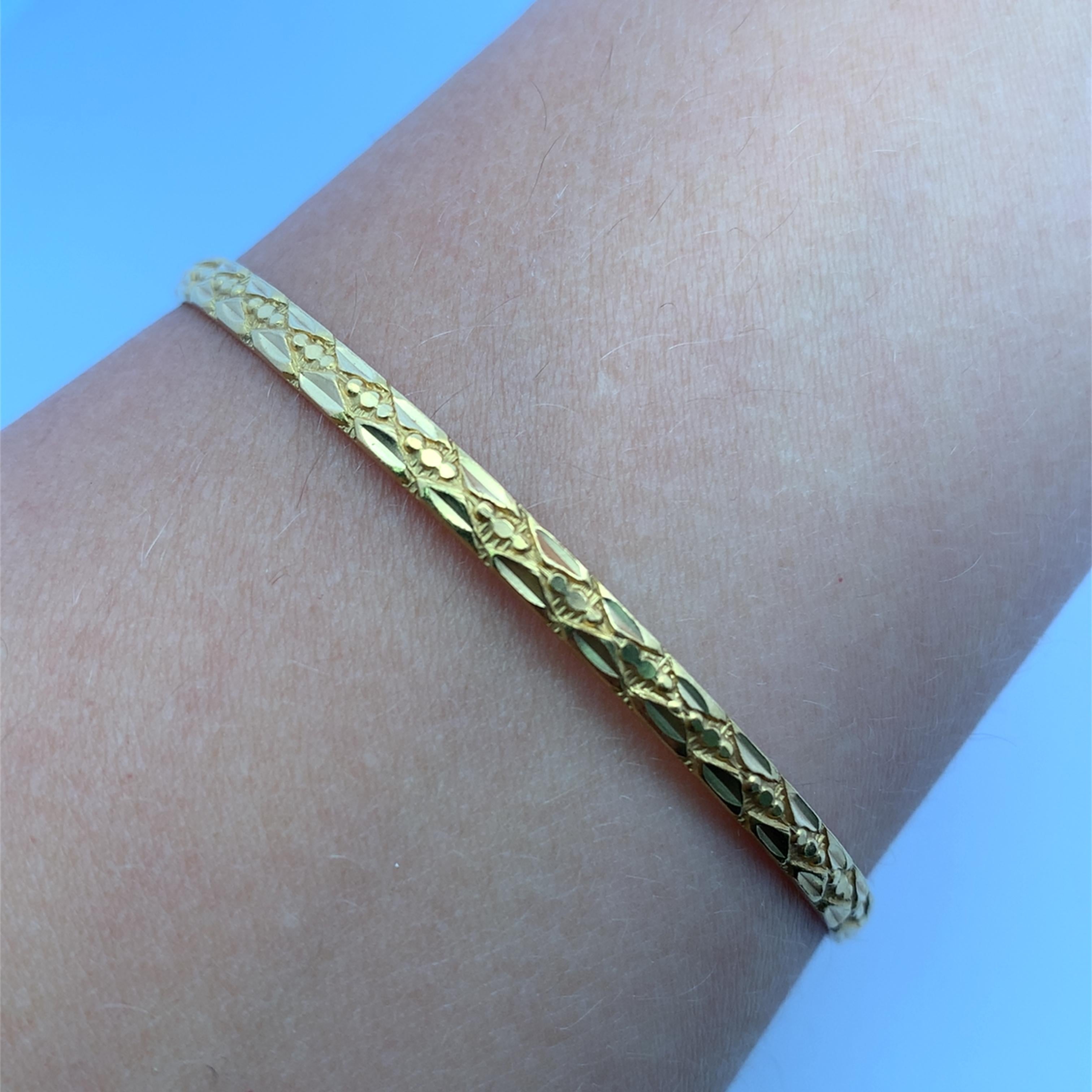 Élevez votre style avec ce bracelet en or jaune 22k à motifs épais. Délicatement gravée de motifs complexes, cette pièce polie ajoute une touche d'élégance intemporelle à tout ensemble. Sa coupe souple et confortable vous permet de porter ce