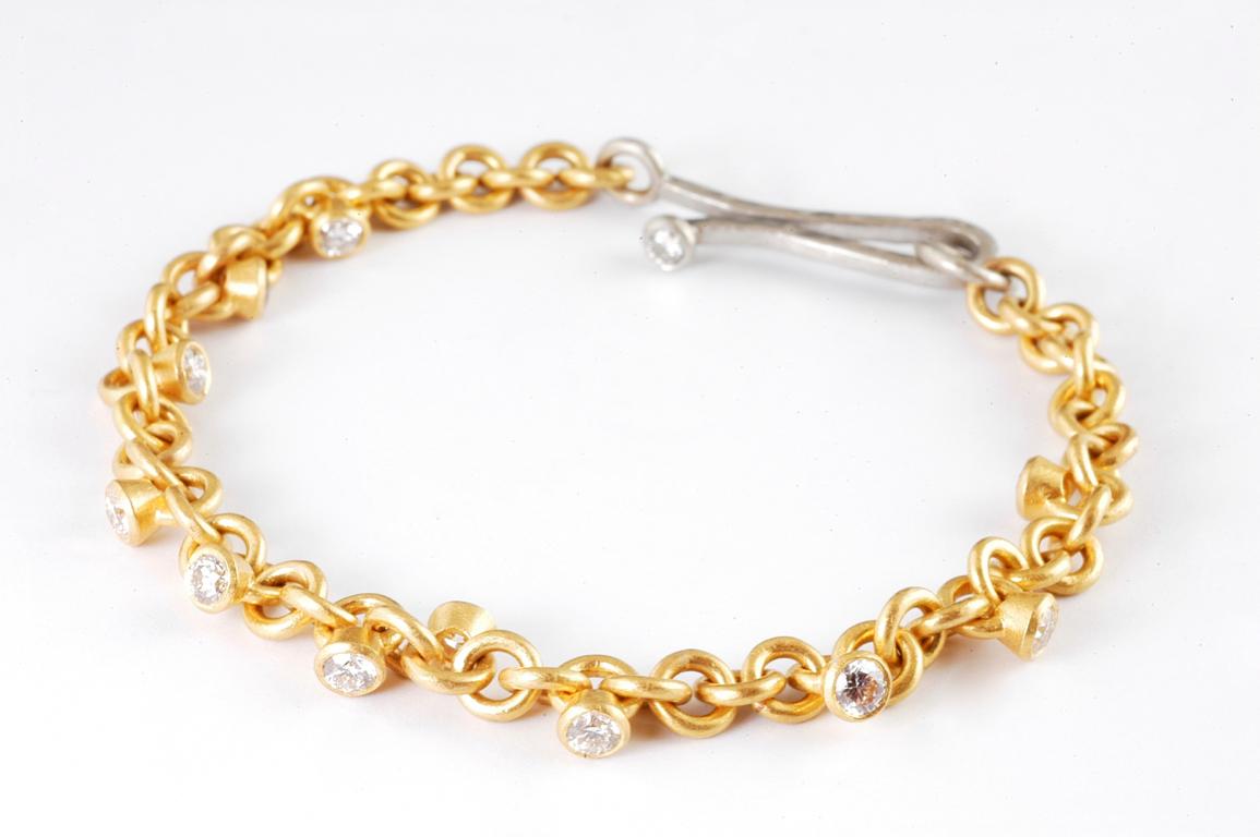 22ct gold hand made link bracelet set with brilliant cut diamond charms  Handmade in Notting Hill London by renowned British jeweller Malcolm Betts.  1.10cts approximate total diamond weight, with platinum catch set with brilliant cut diamond. 
A