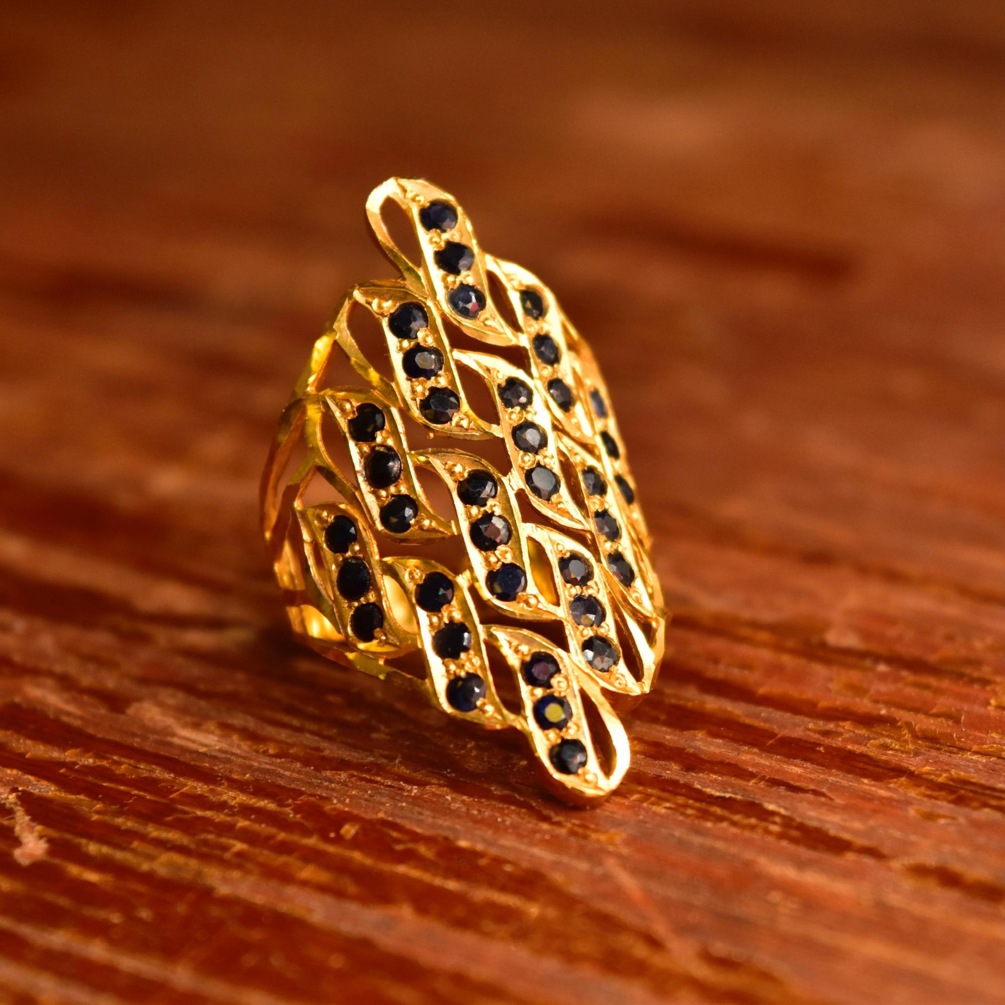 A stunning solid 22kt yellow gold shield ring with dazzling faceted black stone embellishments. This ring is the definition of a statement piece and somehow gets more beautiful the longer your look at it. Featuring a long yellow gold ring face