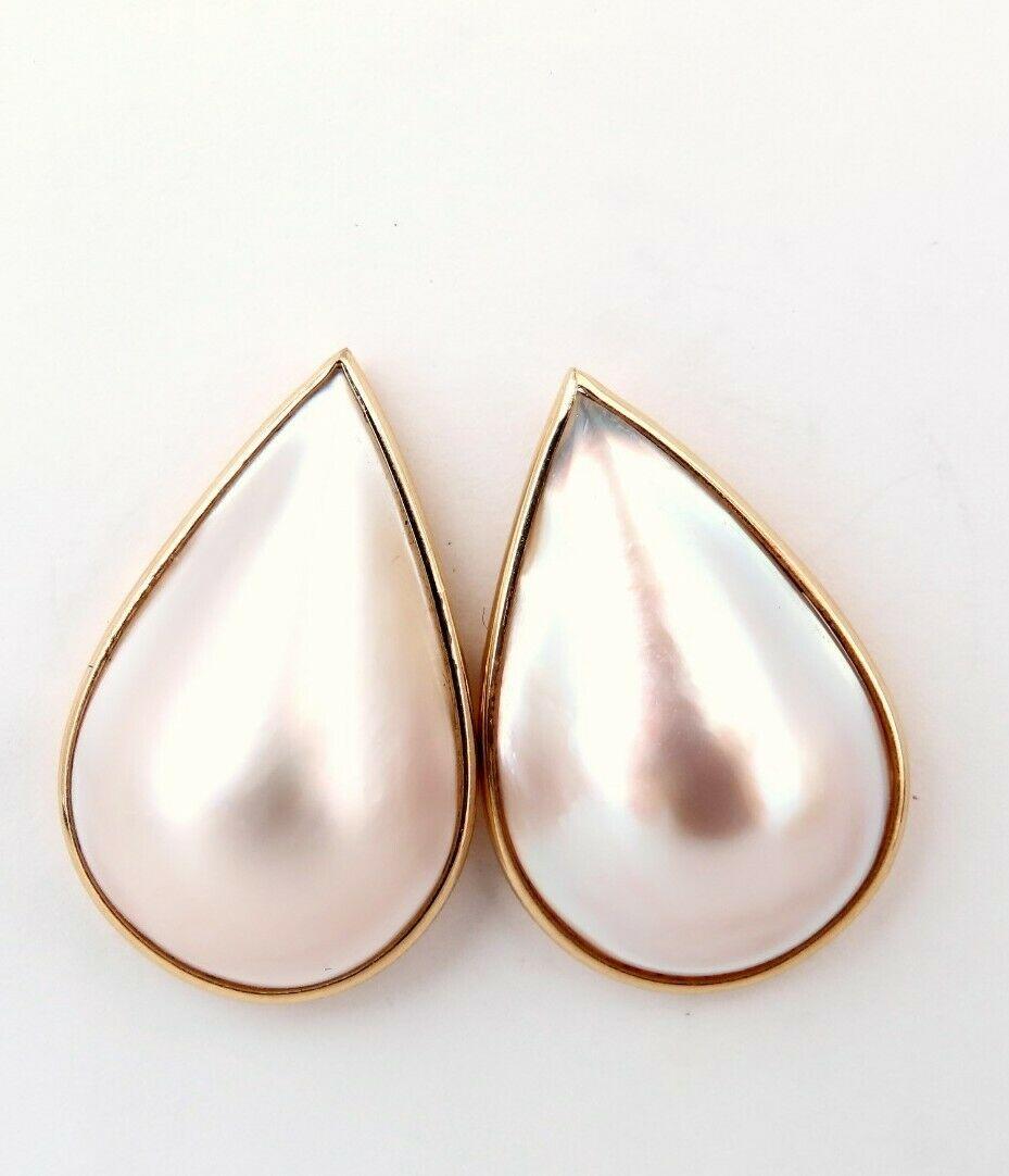 Modernist thin frame Mabe Pearl clip earrings.

22 x 13mm Pearl

Excellent AAA luster and Sheen pink overtone

14 karat yellow gold 5.3 g.

Overall earrings measure 24 x 15.5 mm wide

7.5 mm depth.

Comfortable Butterfly post.