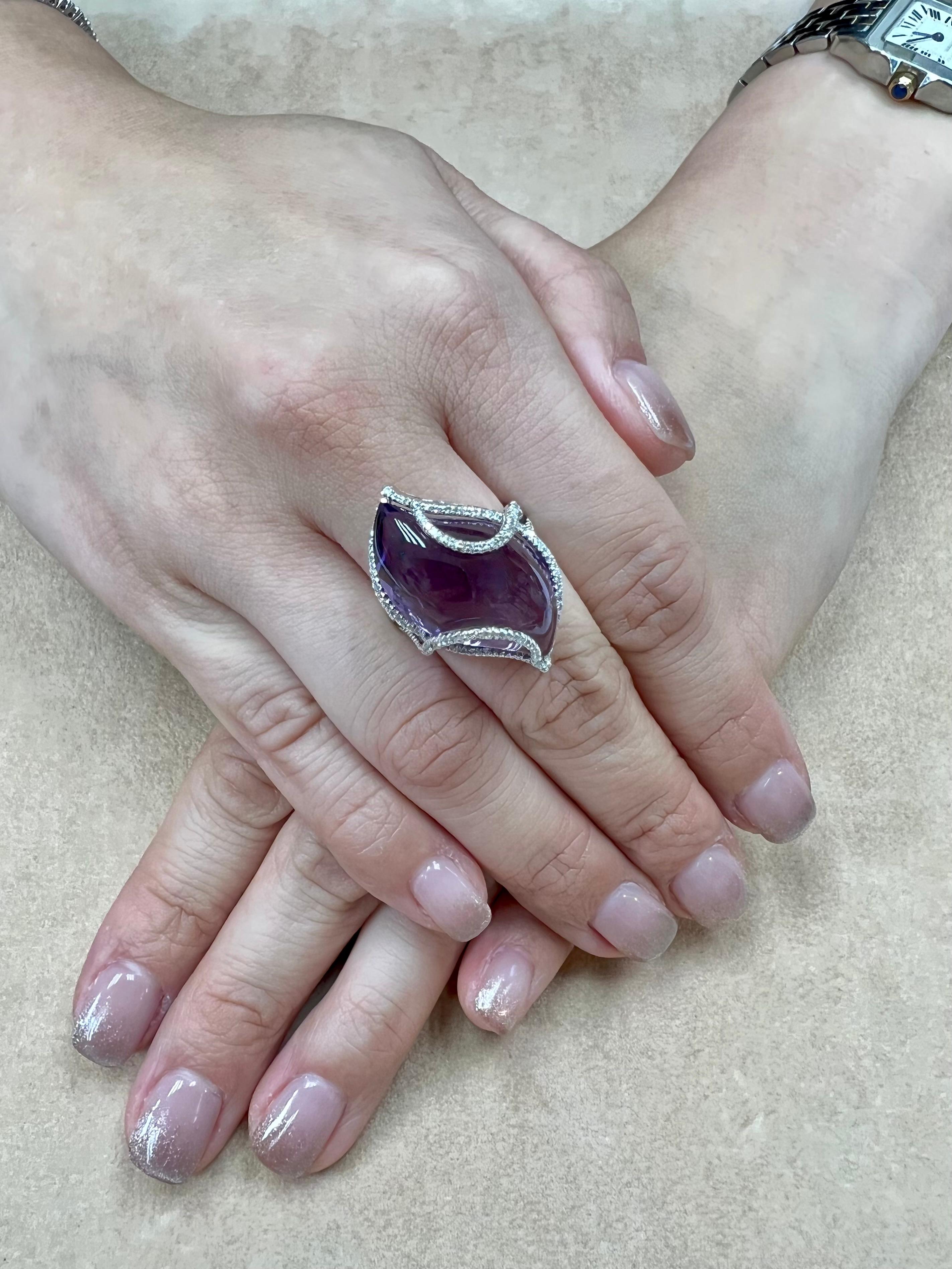 Please check out the HD video! Here is a super unique Amethyst and diamond cocktail statement ring. It is set in 18k white gold and diamonds. The XL 23.25 cts center amethyst is stunning. The violet-purple color shifts from light to dark depending