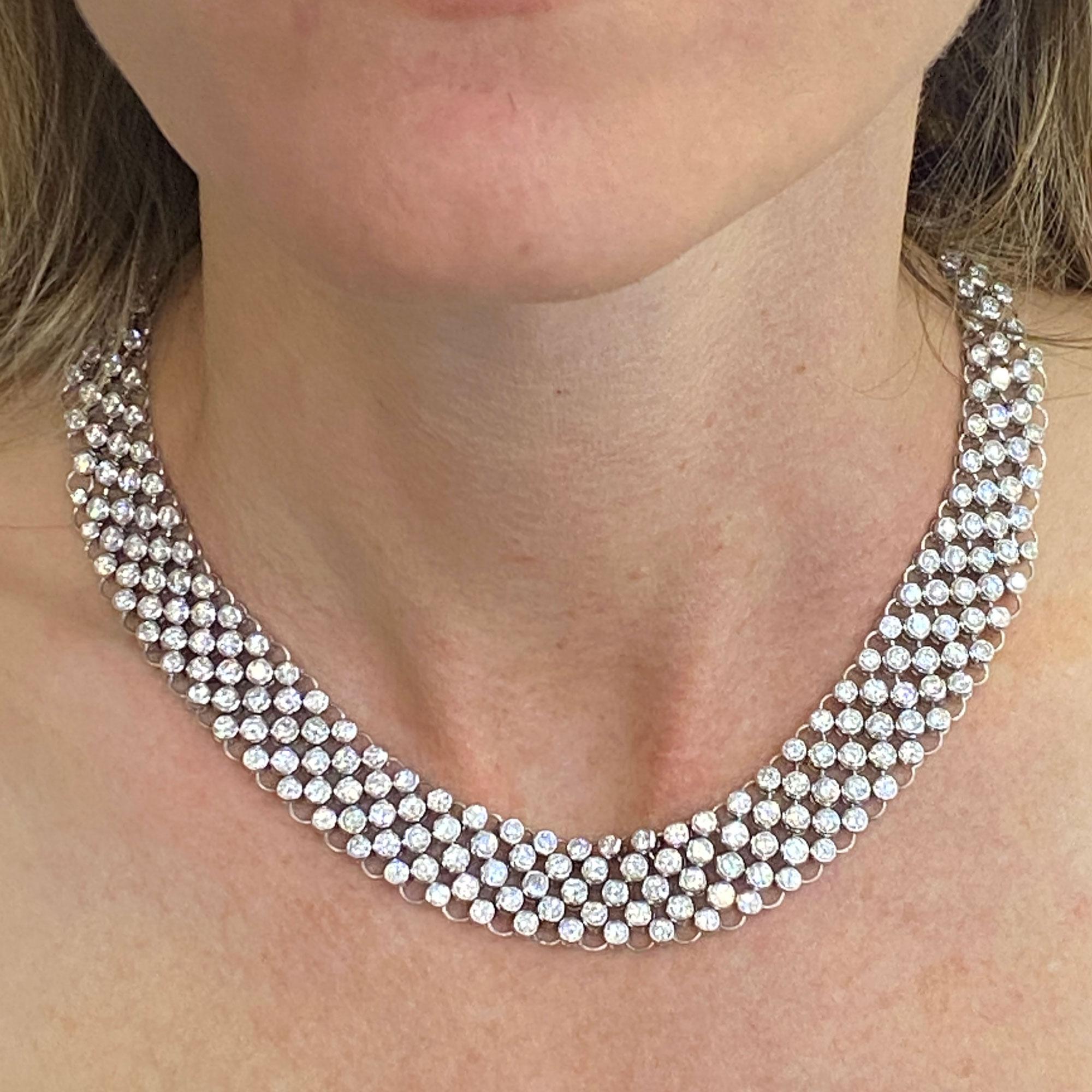 Stunning diamond collar necklace fashioned in 18 karat white gold. The flexible hand crafted necklace features 23 carats of high quality white round brilliant cut diamonds graded G-H color and VS2-SI1 clarity. The necklace tapers and measures 15mm