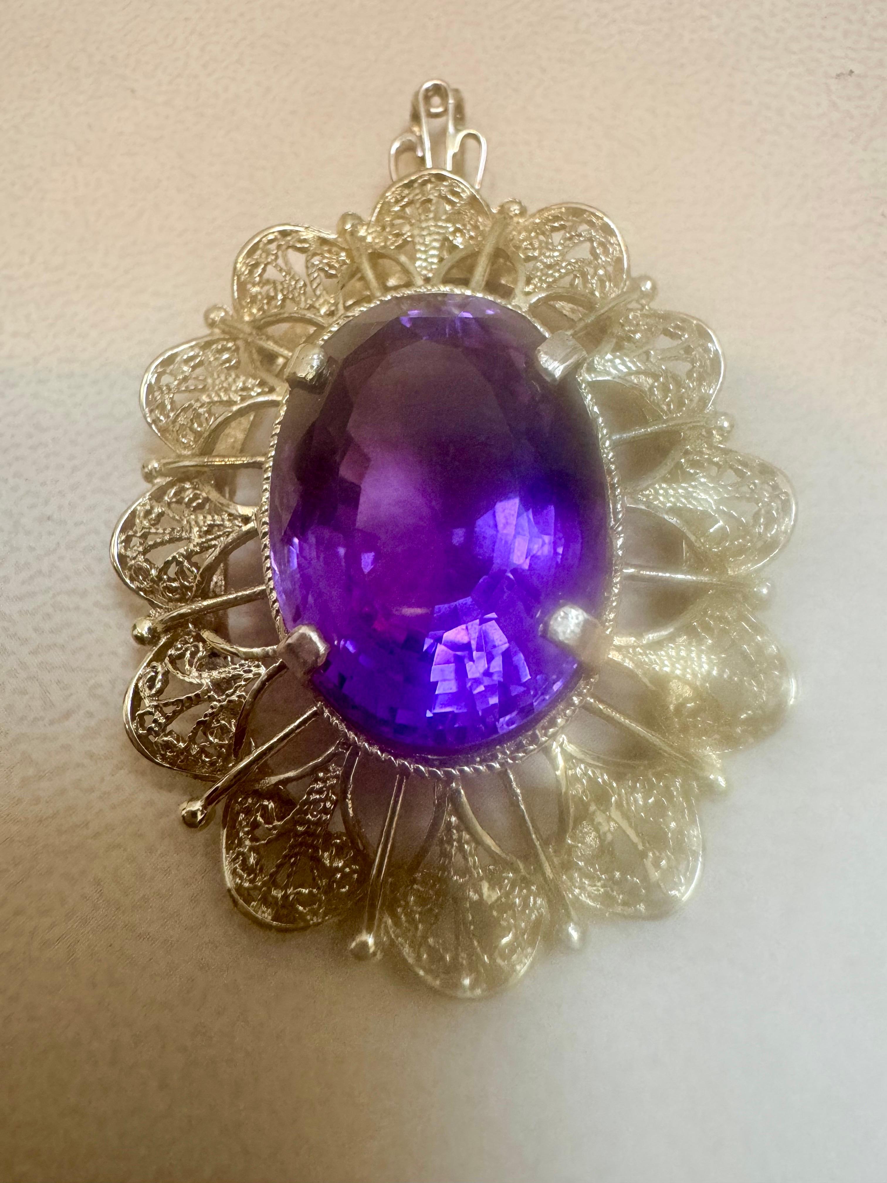  Approximately  23 Carat Amethyst Pendant in 18 Karat yellow gold 

This spectacular Pendant Necklace  consisting of a single large Oval Cut Amethyst , approximately  23 Carat.  The  Amethyst   is surrounded by a intricate design of gold frame. 
18