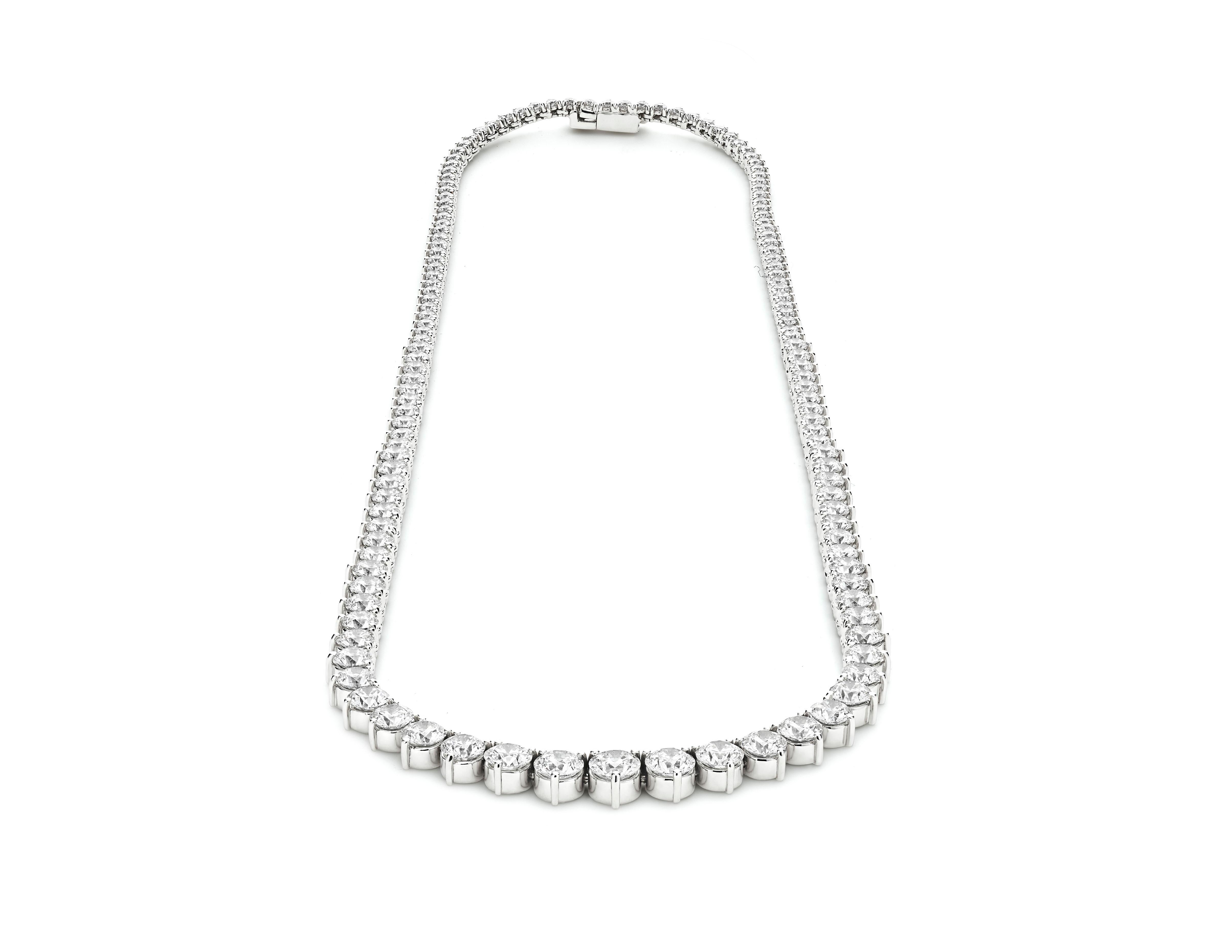This exquisite Riviera tennis necklace boasts a total of 23 carats of dazzling diamonds. The centerpiece of this stunning piece is a prominent 0.70-carat diamond that captures the light beautifully. 

Each diamond is meticulously set in a degradé