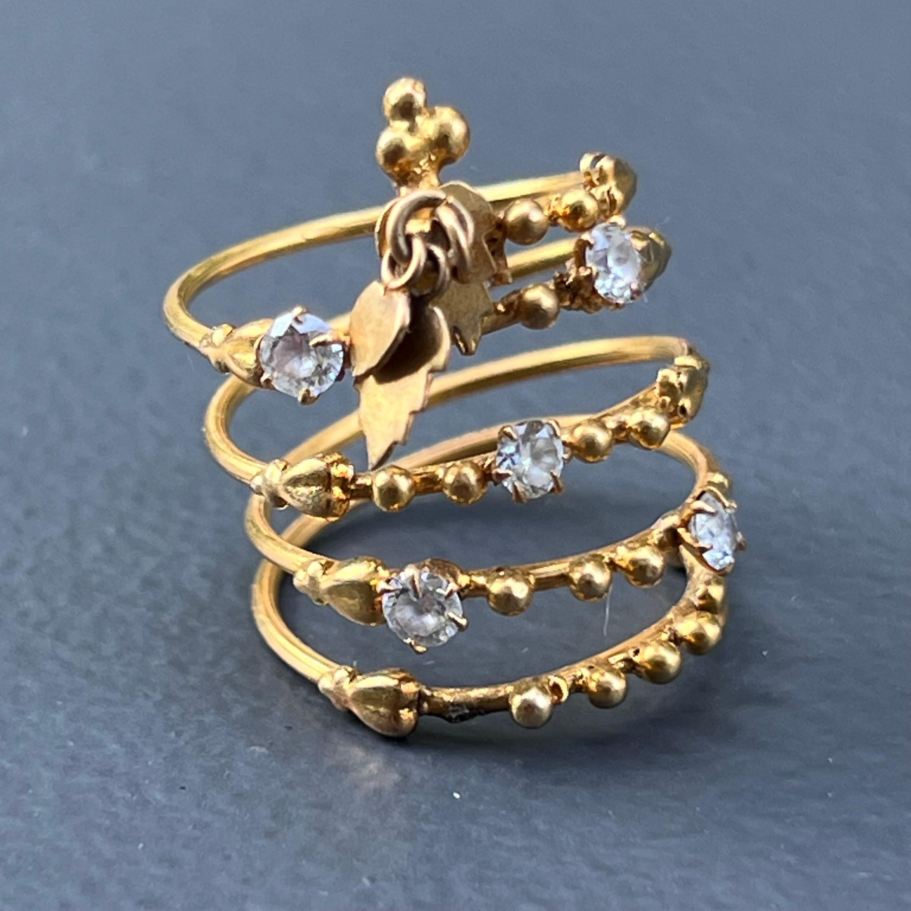  Unusual Mod/ Modern handmade 23 karat solid gold coiled ring with prong set cubic zircons. Ring is handmade and has four coils with fine details and features Etruscan style applied small ball beads and two cute dangles /charms on front side .