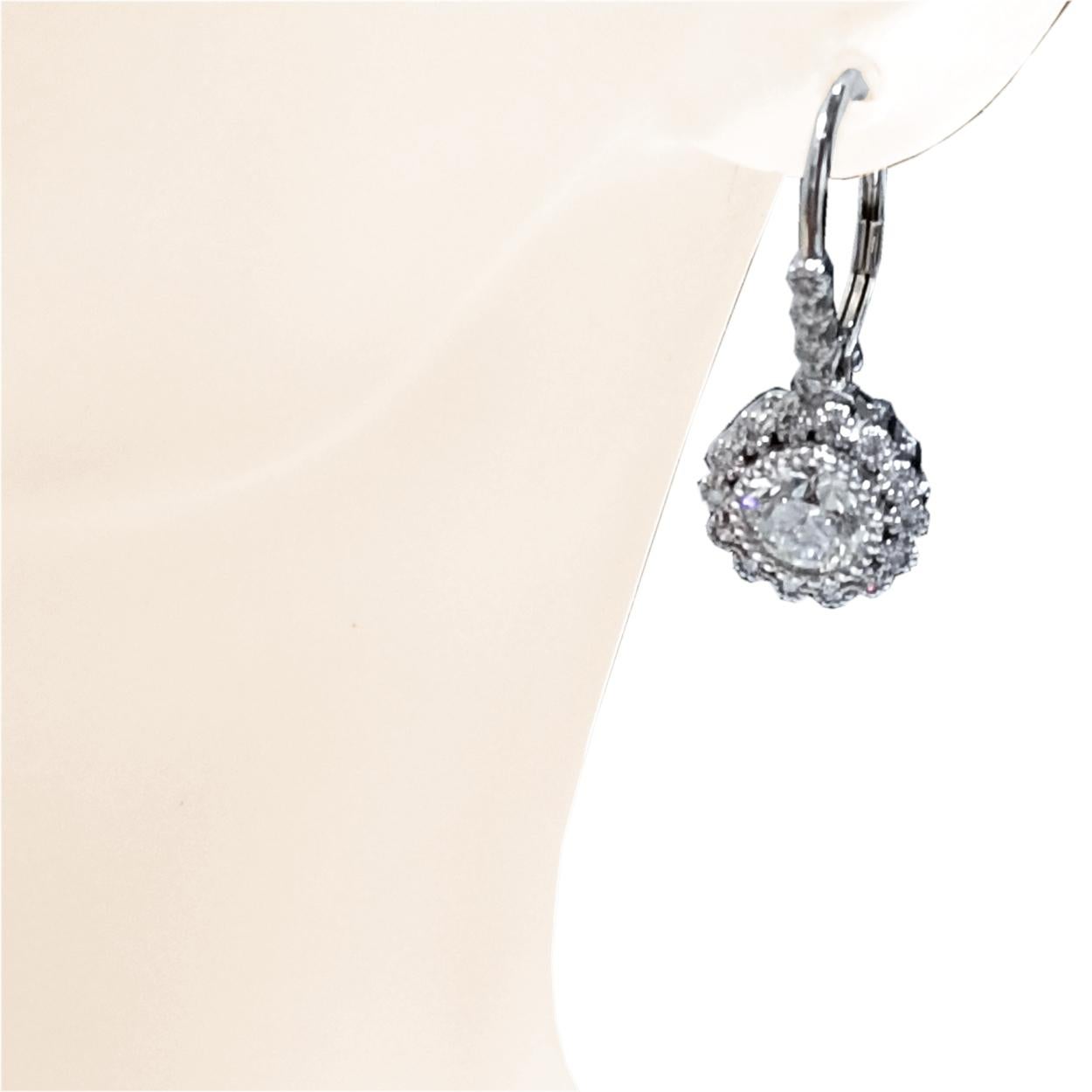 Cette magnifique paire de boucles d'oreilles pendantes est fabriquée en or 14K avec 36 diamants ronds brillants sertis en pavé Halo & Bale (poids total 0,31 Ct). Elle abrite une paire de diamants ronds brillants de 1 ct chacun (poids total de 1,99