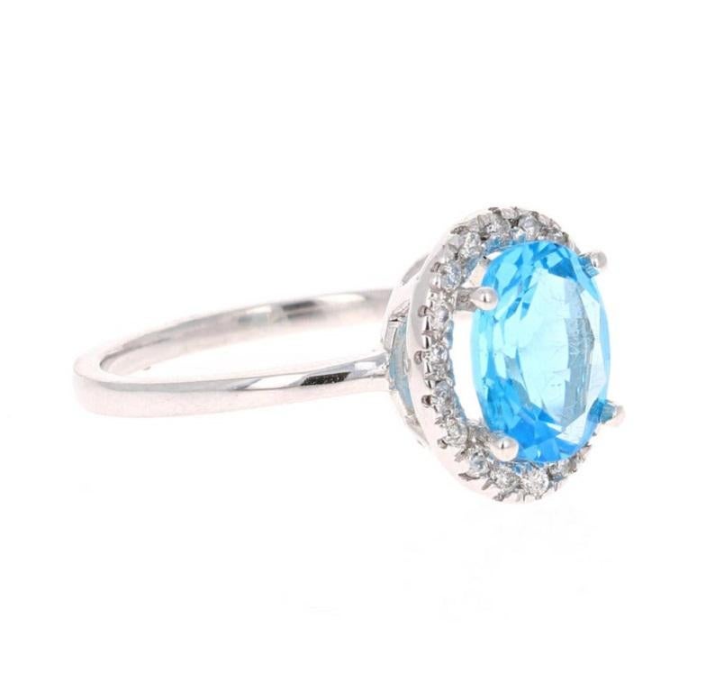 This beautiful Oval cut Blue Topaz and Diamond ring has a stunning 2.15 Carat Blue Topaz and its surrounded by 18 Round Cut Diamonds that weigh 0.15 Carats. The total carat weight of the ring is 2.30 Carats. The setting is crafted in 14K White Gold