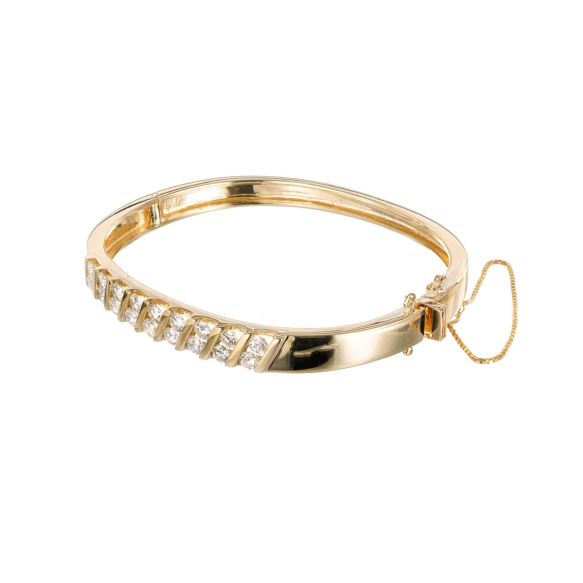 bracelet bangle avec 18 diamants ronds taille brillant. Sertie de deux rangées diagonales de chaînes dans un bracelet bangle en or jaune 14k. Figure 8 et chaîne de sécurité pour la sécurité. 

18 diamants ronds de taille brillant H-I VS-SI, poids