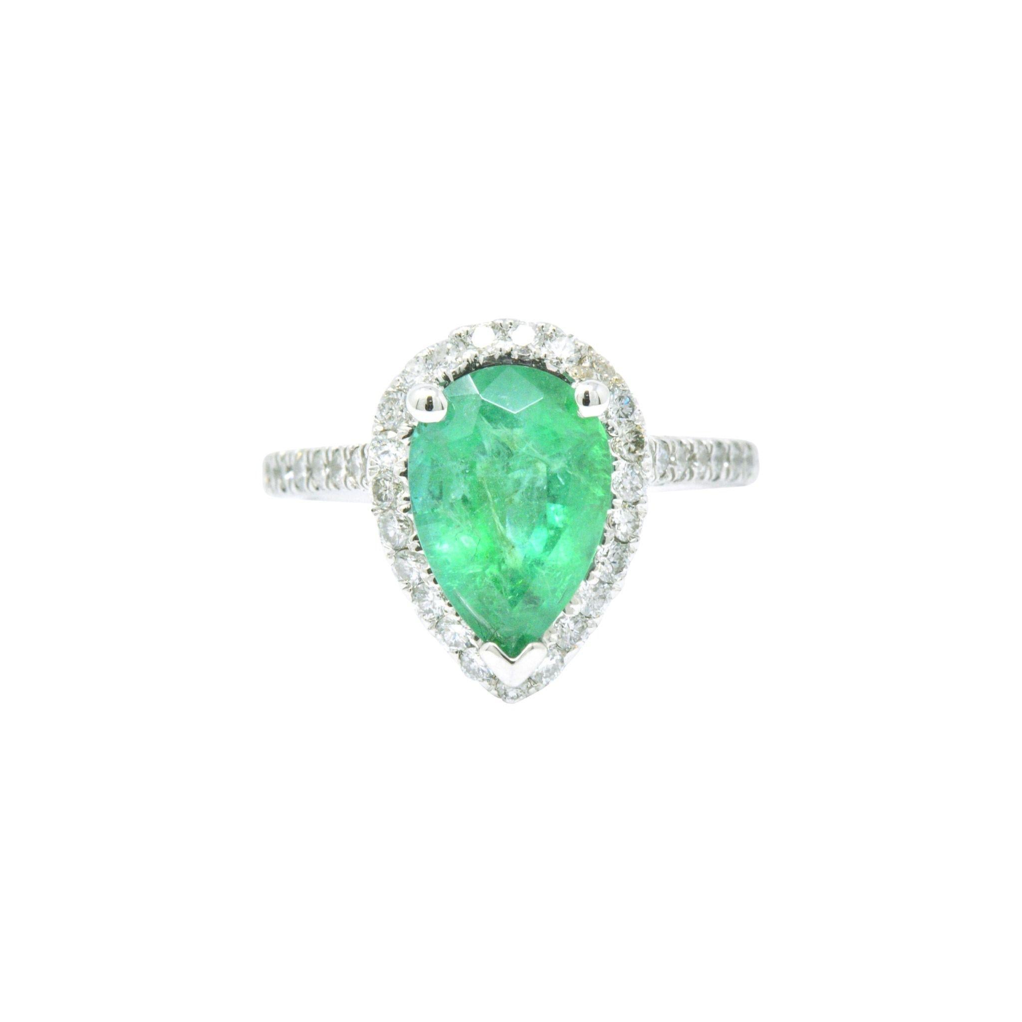 Centering a pear cut emerald weighing approximately 2.30 carats, bright springy green

In a round brilliant cut diamond 