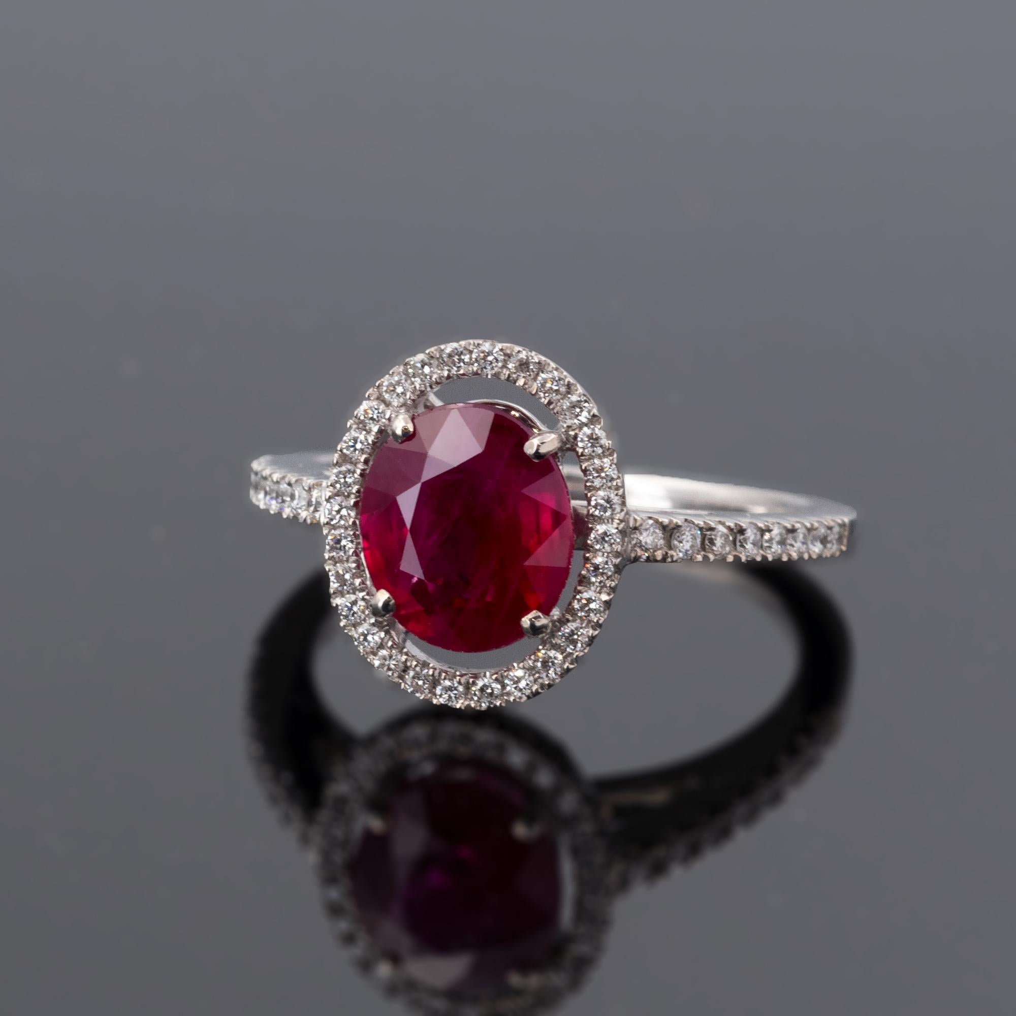 Bague de fiançailles intemporelle mettant en valeur un rubis birman ovale de 2,30 carats présentant la couleur rouge riche et intense recherchée. La bague en or blanc 18 carats est sertie de 0,25 carat de diamants blancs taillés en brillant.
