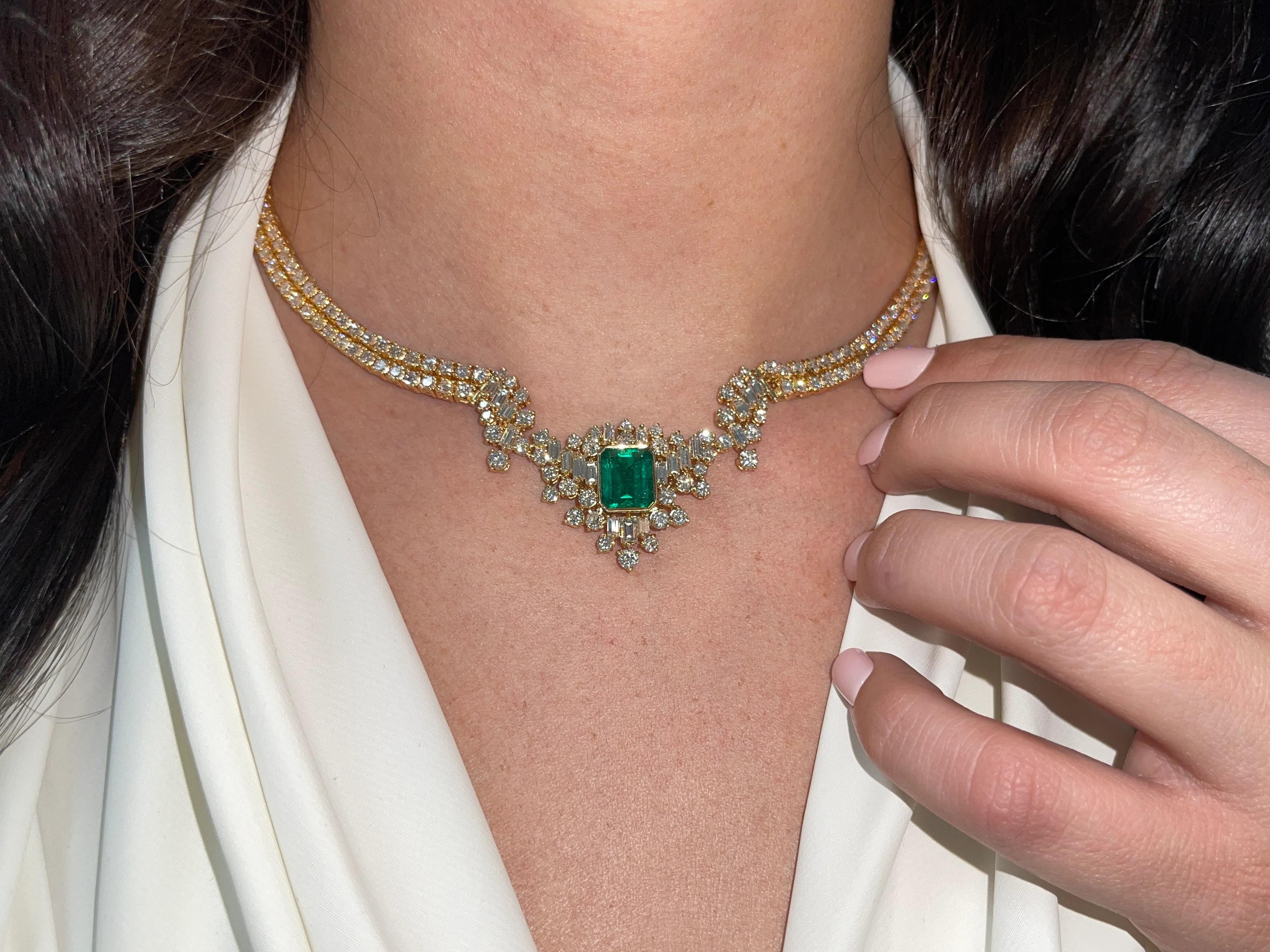 Displayed is an investment quality, vivid Muzo green Colombian emerald and diamond statement necklace. An extraordinary 3.85 carat, earth-mined emerald weighs 3.85 carats and is bezel set in sleek, 18K gold. Three hundred twenty-six diamonds are