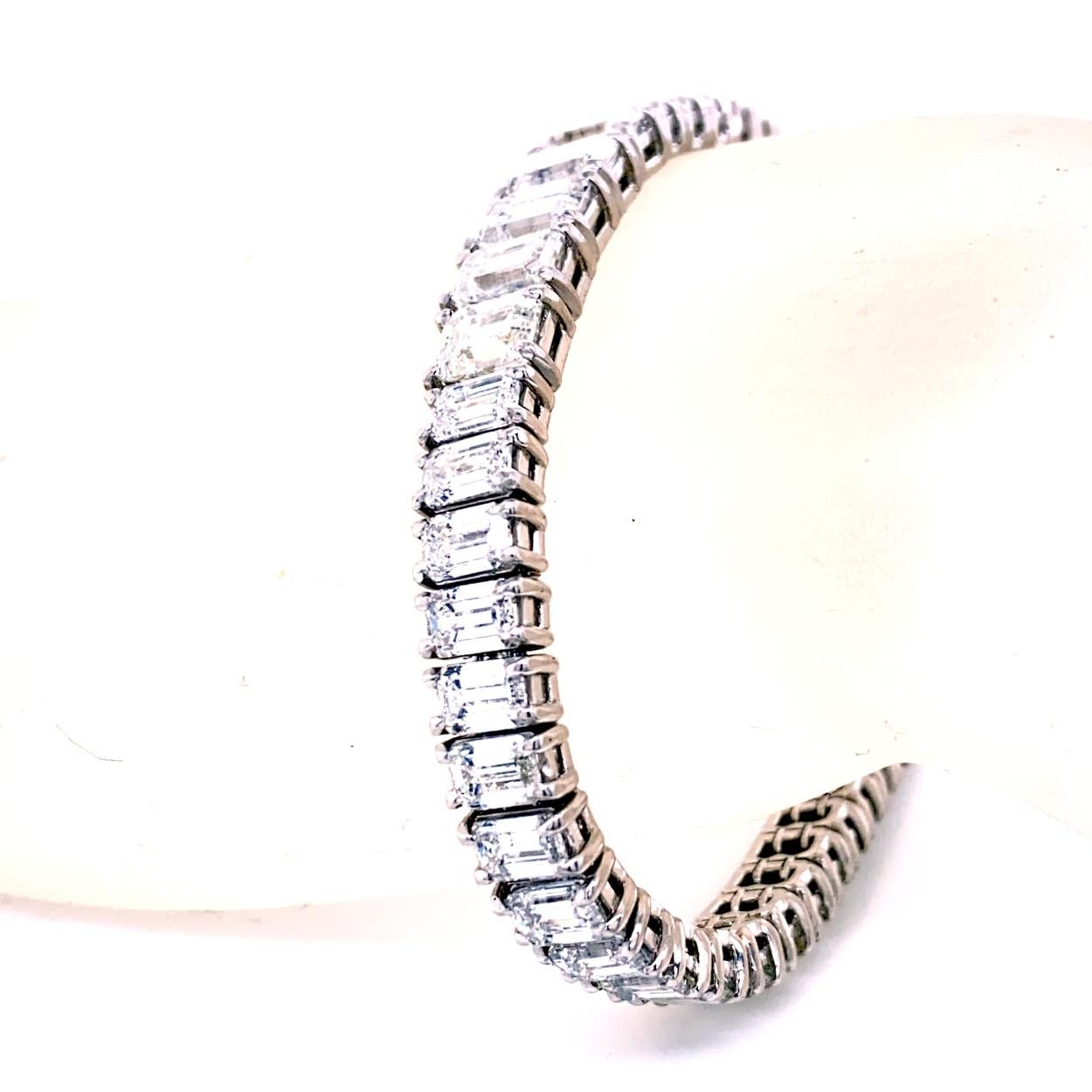 This Diamond Tennis Bracelet consists of 49 Links of graduated Emerald Cut diamonds set in platinum.  The center 5 pieces are approximately 1.00 Ct  each. The bracelet comes with a built-in hidden safety lock to protect it from loss. 
Total Weight