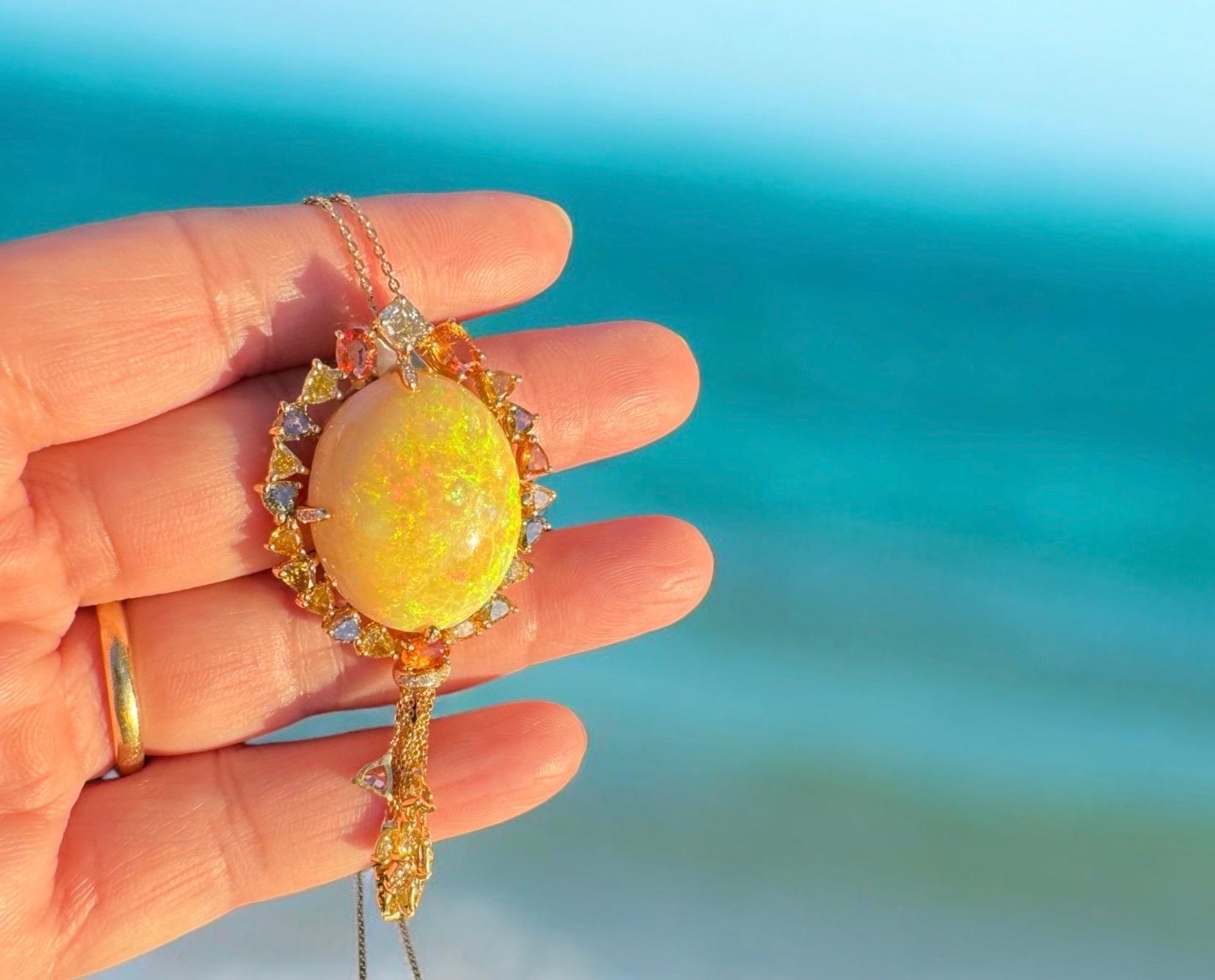 Préparez-vous à être hypnotisé par ce superbe pendentif de bo•être des bijoux. En son cœur se trouve une opale éthiopienne de 23,09ct à couper le souffle, dont le jeu de couleurs danse à chaque mouvement. Cette pierre rare est entourée de quatre
