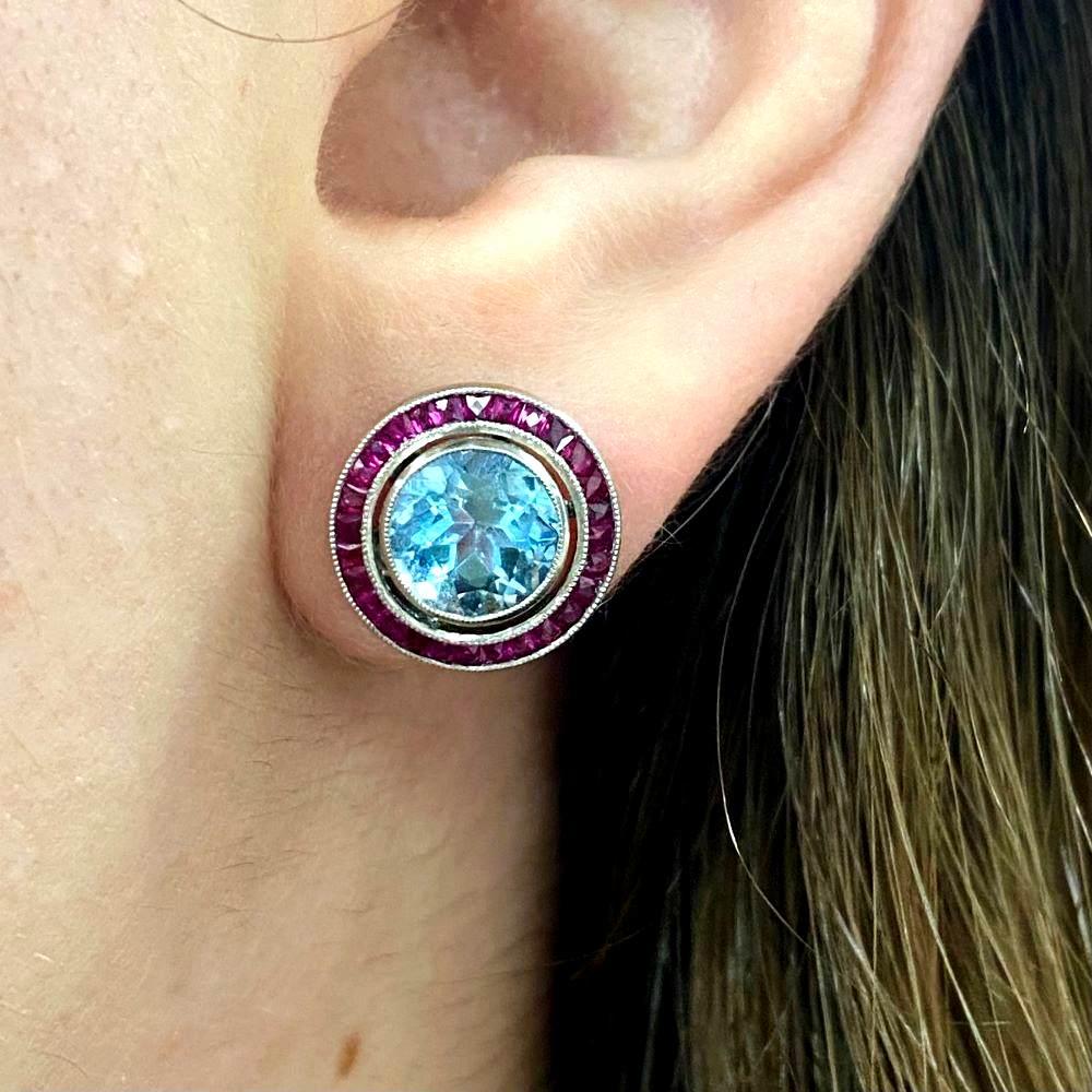 Indulge in the captivating allure of these exquisite gemstone earrings. The focal point of each earring is a pair of vibrant aquamarines, exuding a mesmerizing ocean-blue hue with strong saturation. Their lively colors evoke the tranquil beauty of a