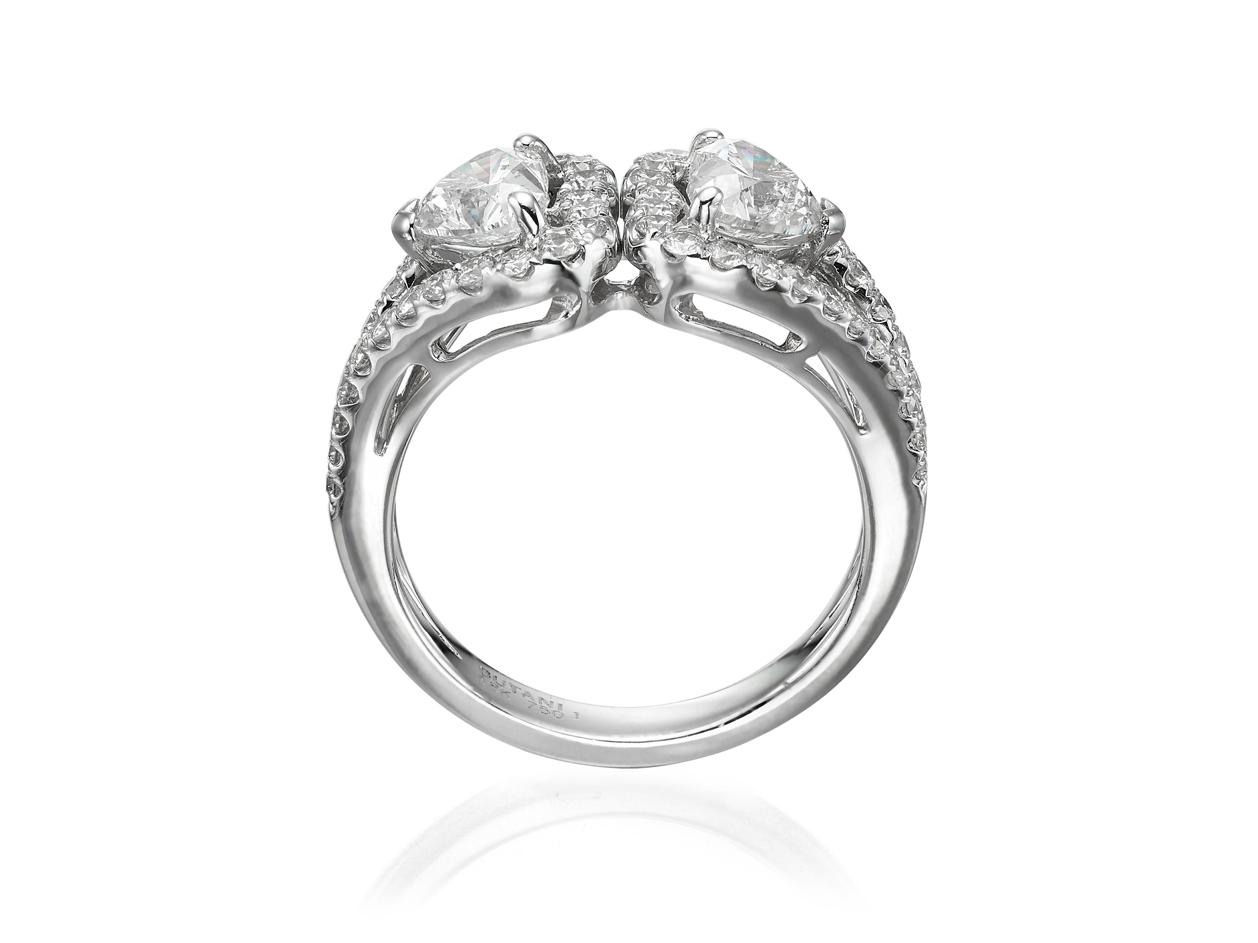 Crafted from 18K white gold, this cocktail ring features two heart shape diamonds (totaling 1.61 carats) surrounded by a halo of round diamonds (totaling 0.7 carats).  Currently a ring size US 6.5.  For other sizes, please contact