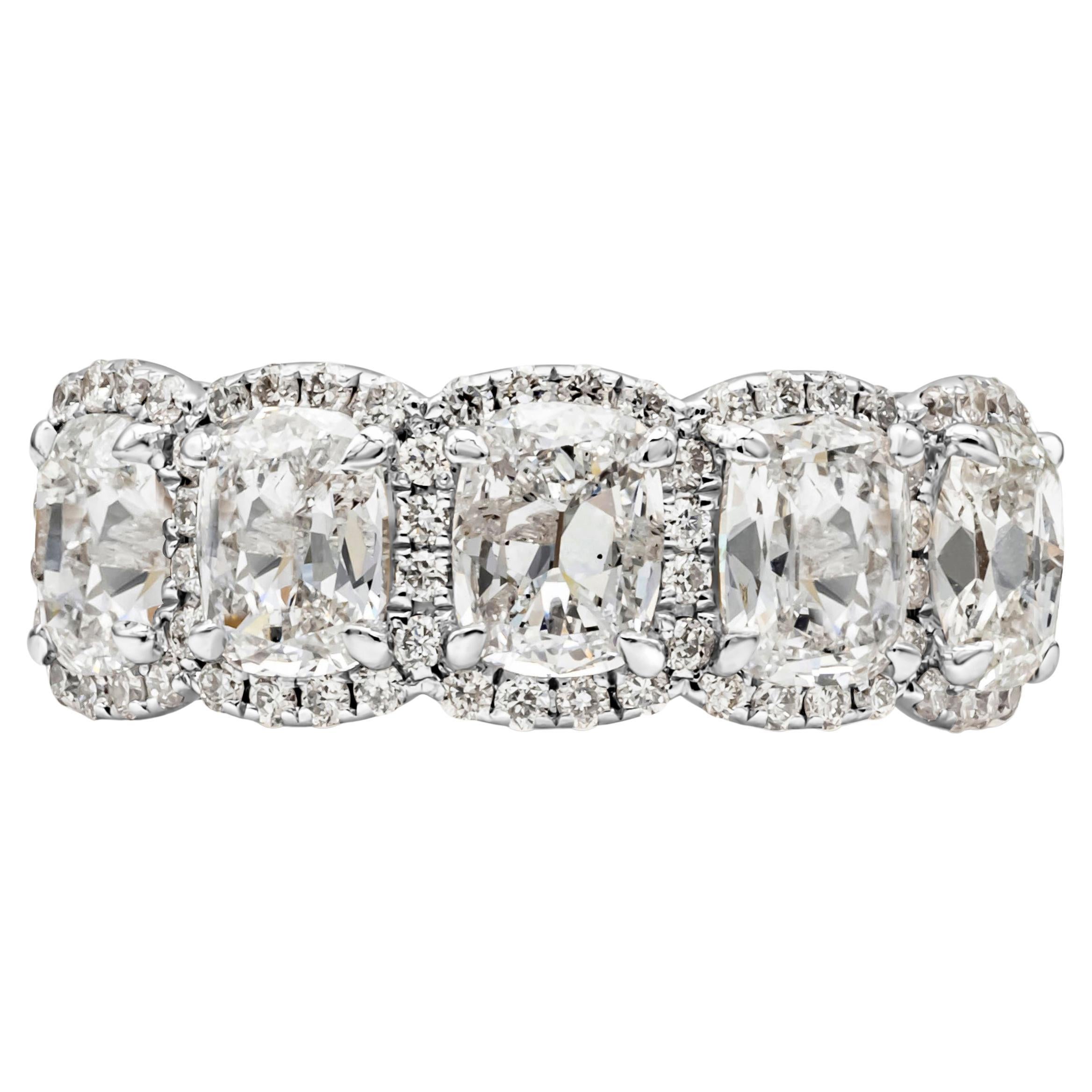 An elegant and stunning wedding band showcasing five cushion cut diamonds weighing 2.31 carats total, E color and S12-I1 in clarity, set in a classic 18k white gold four prong  basket setting. Each surrounded by a single row of round brilliant