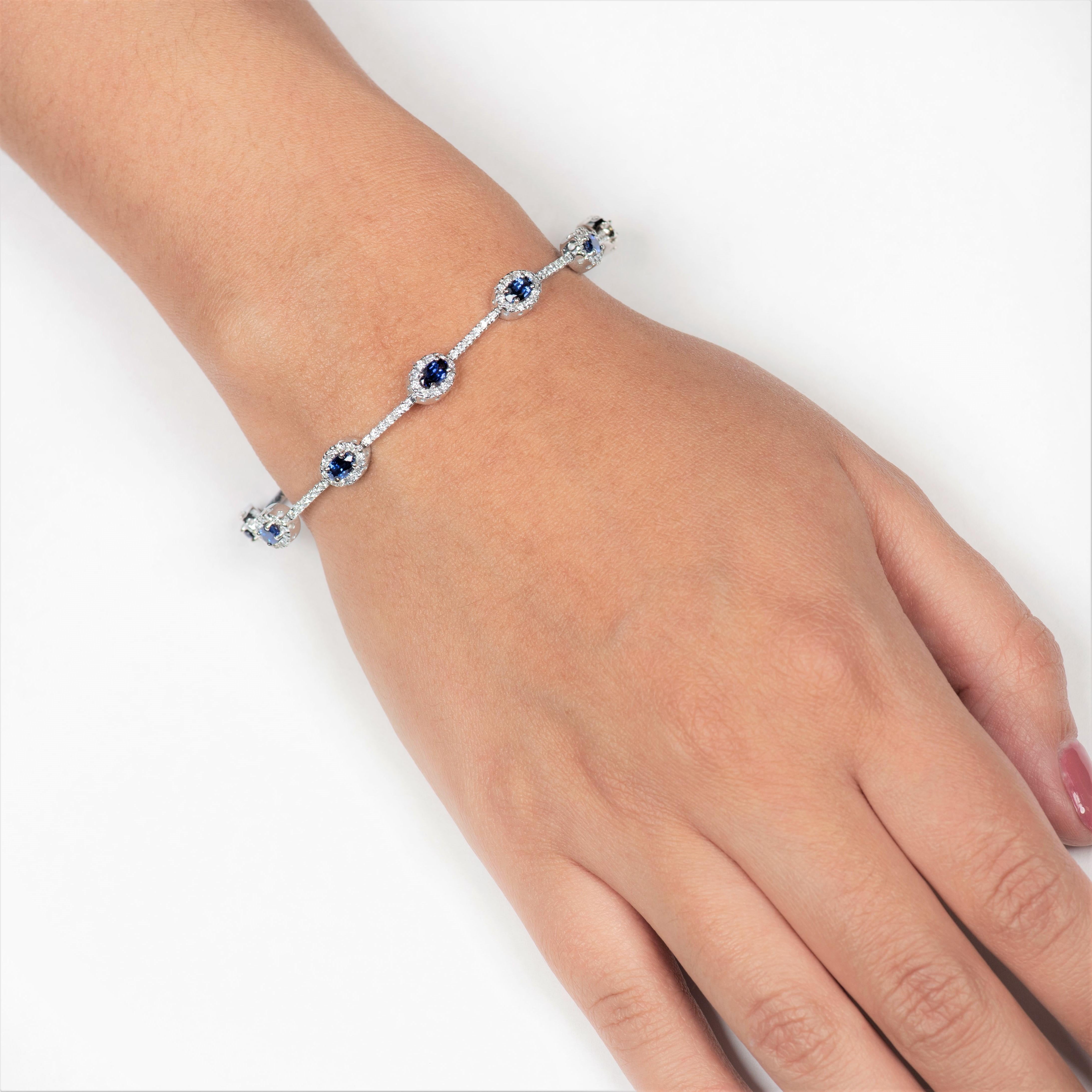 Alluring 2.32 Carats blue sapphire bracelet styled with 10 perfectly matched oval cut sapphires that are surrounded by 1.37 carats of round diamonds (180 diamonds).
The bracelet measures at a length of  7 inches and is designed in 14K white gold.