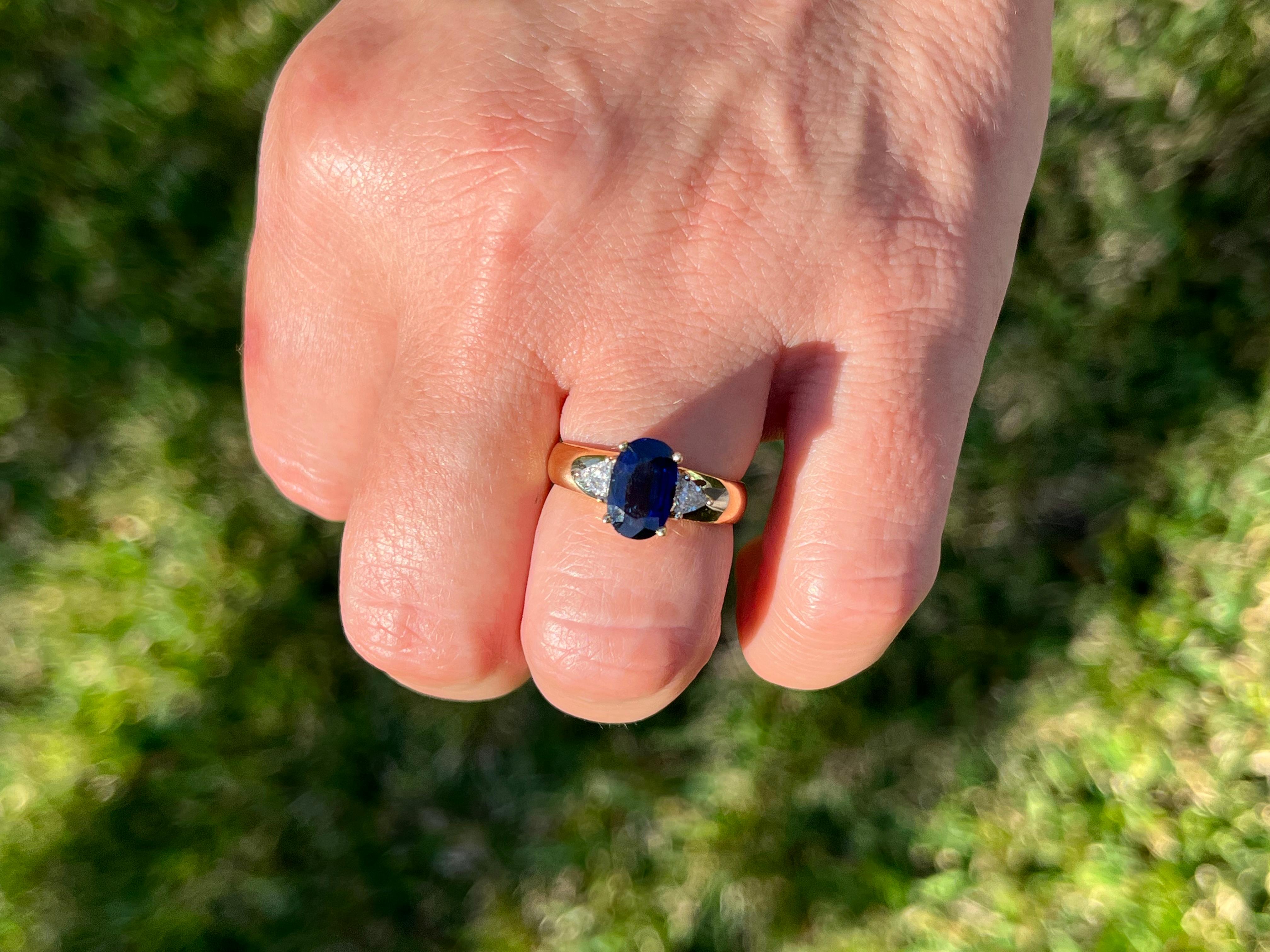 2.32 Carat Oval Cut Blue Sapphire with Trillion Cut Diamond Sidestones in 18k In New Condition For Sale In Miami, FL