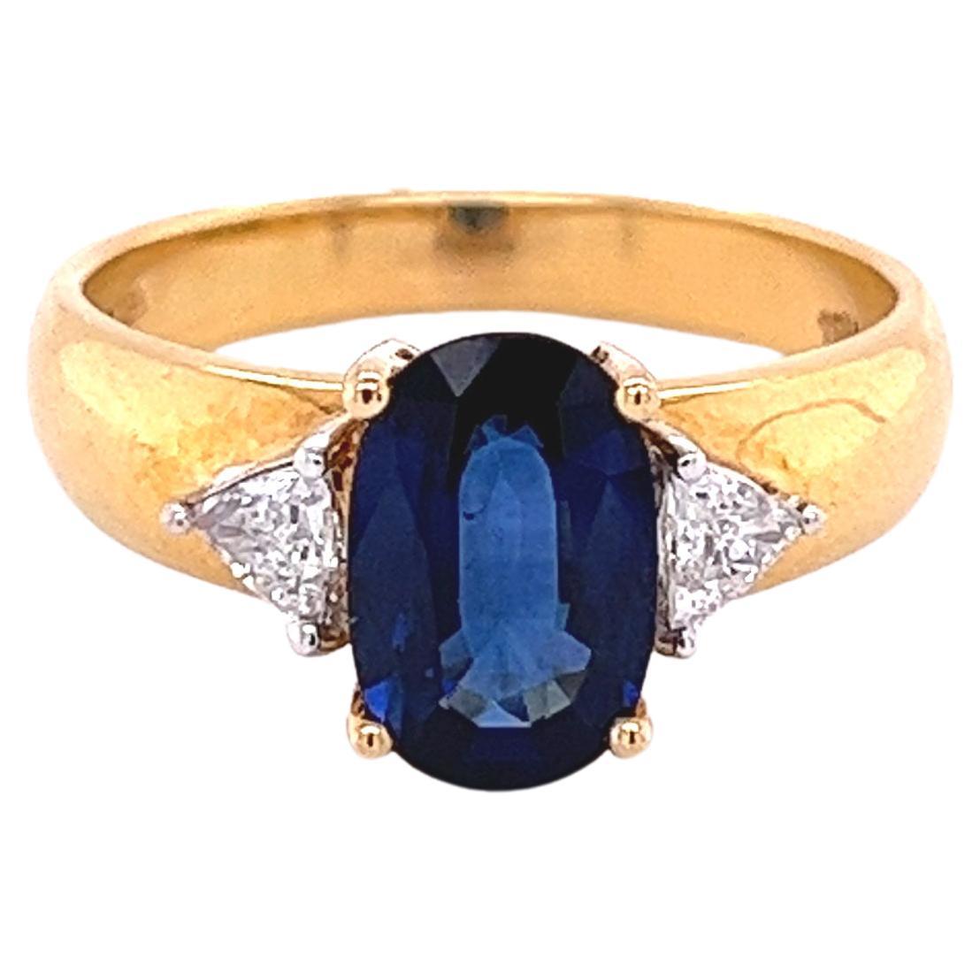 2.32 Carat Oval Cut Blue Sapphire with Trillion Cut Diamond Sidestones in 18k  For Sale