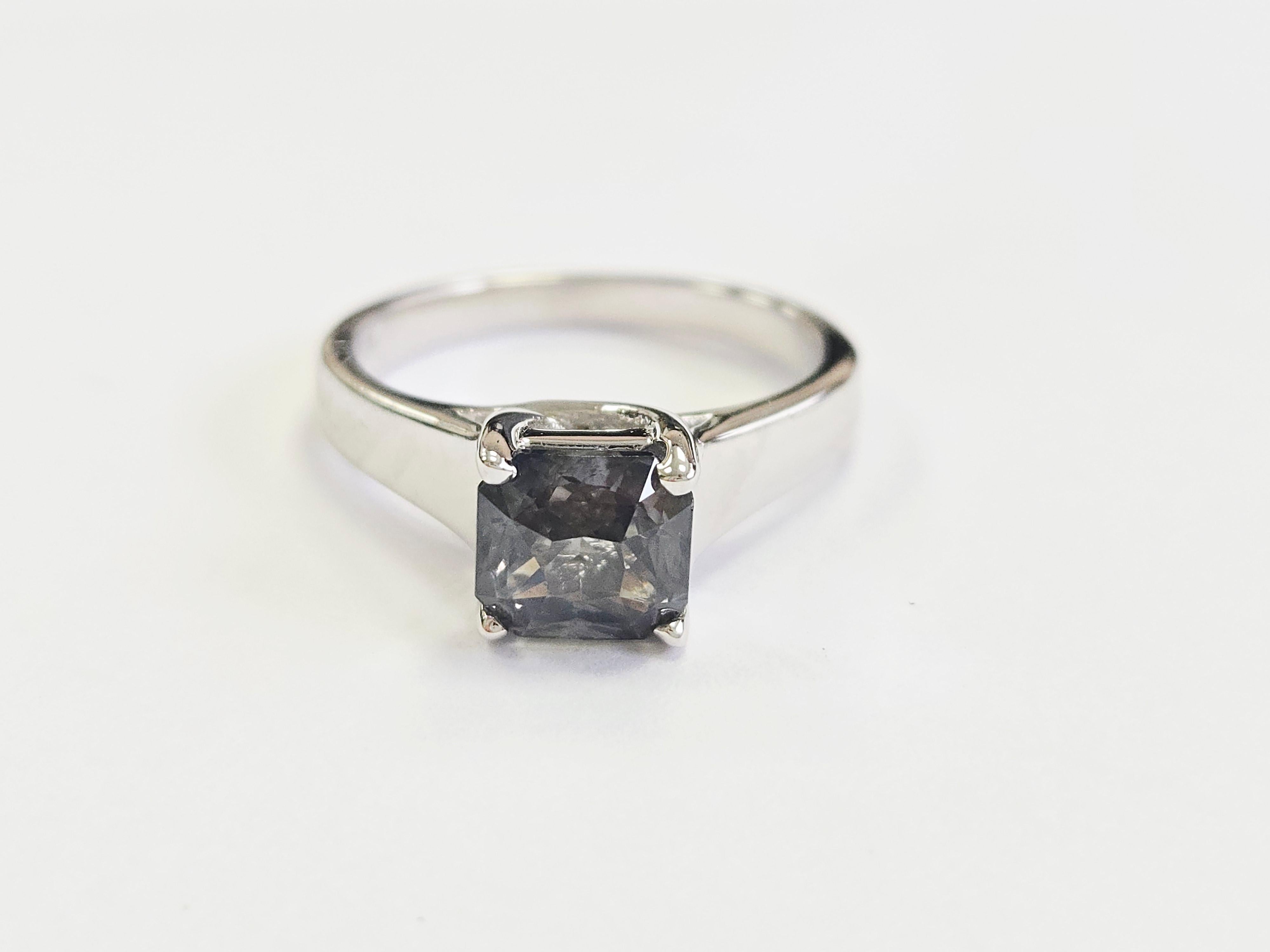 Exuding rare elegance and understated brilliance, this exquisite ring features a stunning 2.32-carat natural green sapphire in a sophisticated radiant cut. The unique color of the sapphire—rich forest green with subtle teal undertones—offers an