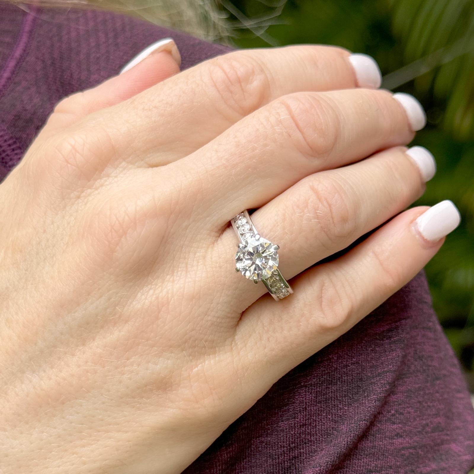 This elegant 14-karat white gold diamond engagement ring showcases a breathtaking 2.32-carat round brilliant-cut center diamond, graded H in color and SI2 in clarity, with certification by EGL (certificate number 2421437225). Accentuating the center