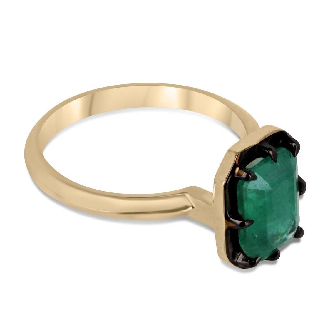 Displayed is an elegant, natural emerald solitaire emerald-cut engagement ring/right-hand ring in 14K yellow gold, with a black rhodium rim. This gorgeous solitaire ring carries a full 2.32-carat Zambian emerald in an eight-prong Georgian/collet