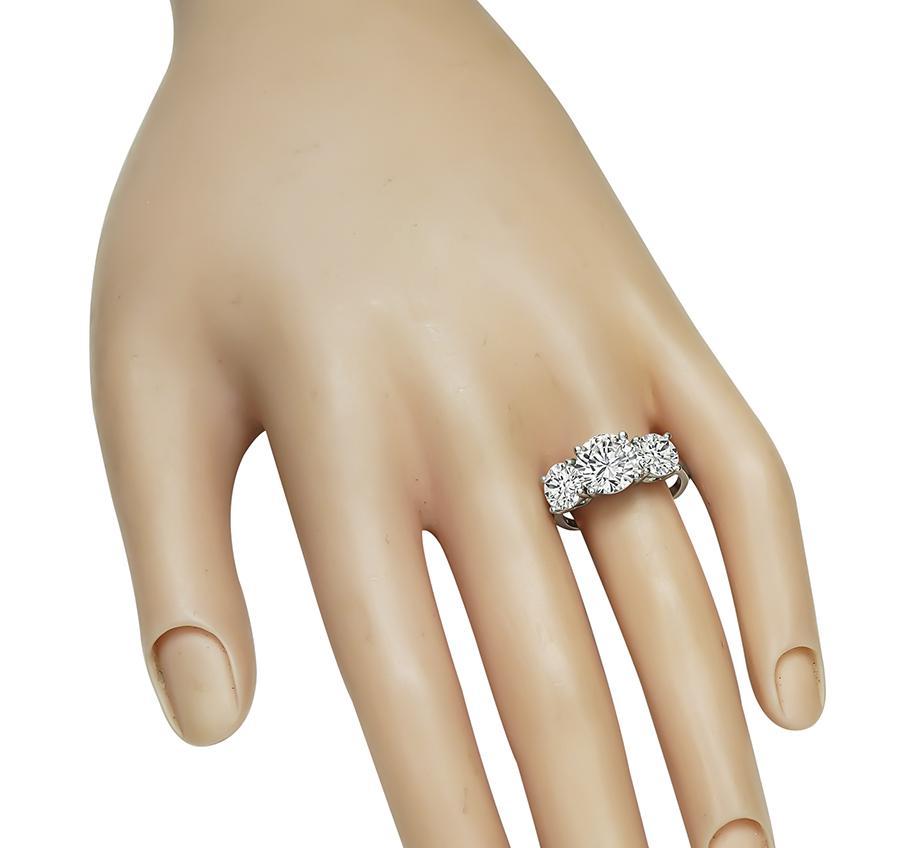 Este es un anillo de compromiso de platino increíble. El anillo está centrado con un brillante diamante de talla redonda que pesa aproximadamente 2.32 ct. El color del diamante es I-J con claridad VS2. El diamante central está acentuado por dos