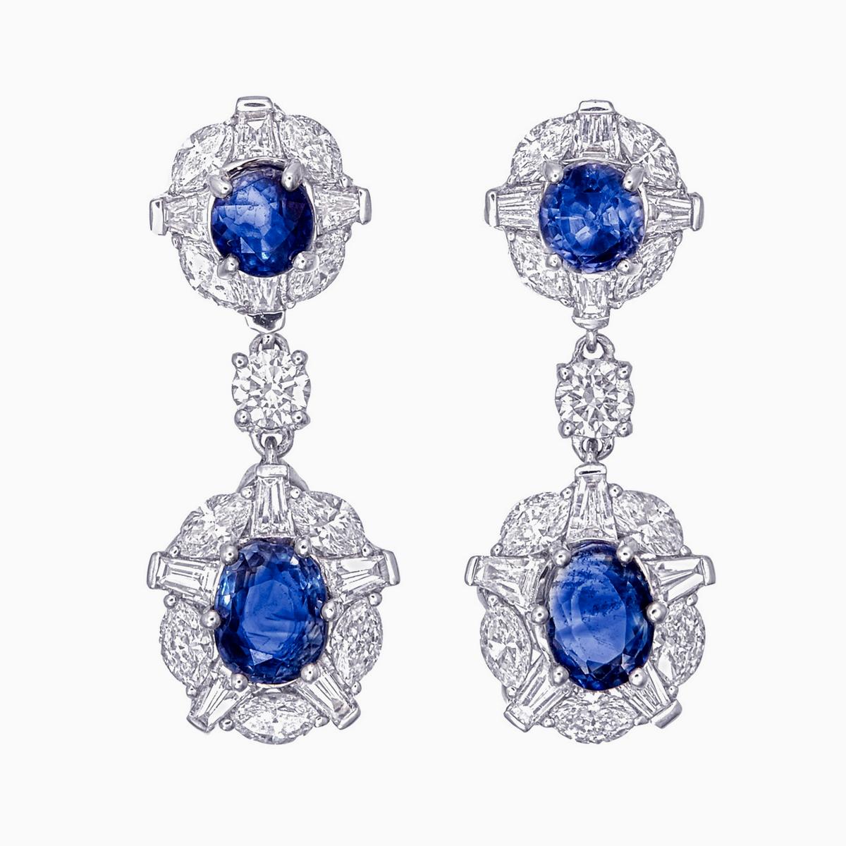 Une élégante paire de boucles d'oreilles chandeilier en saphir bleu du Cachemire et diamants de Rewa Jewels est réalisée en or blanc 18 carats.

Les 4 pièces centrales sont des saphirs bleus du Cachemire pesant environ 2,33 carats. Les saphirs bleus