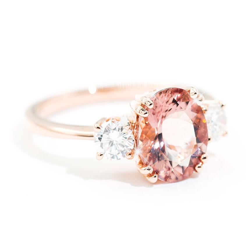 Crafted in 18 carat rose gold is this vintage inspired three stone ring featuring an ever-so lovely 2.33 carat oval Morganite flanked by two alluring round cut brilliant diamonds totalling 0.53 carats. We have named this wondrous ring The Cuba Ring.