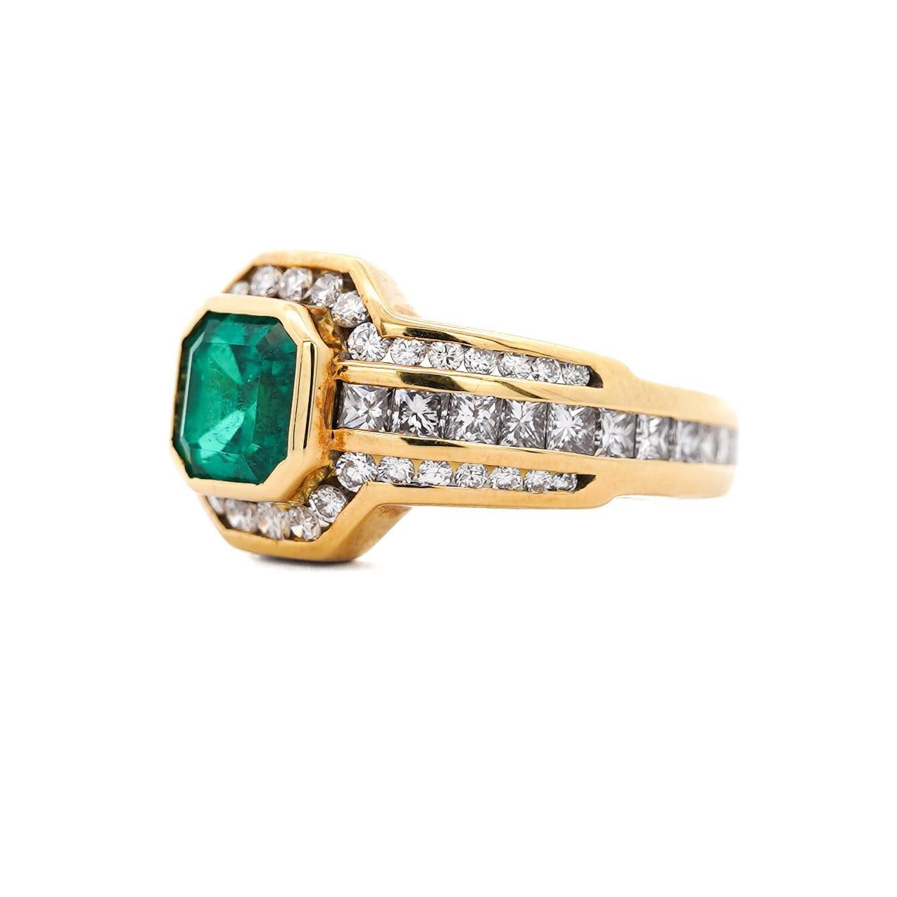 Natürlicher Smaragd- und Diamant-Cocktailring mit einem Smaragd von 1,33 Karat im Smaragdschliff, umgeben von einem achteckigen Halo mit insgesamt 1 Karat prinzessinnenförmigen und runden Diamanten in einer Dreierreihe aus 18 Karat Gelbgold. Größe