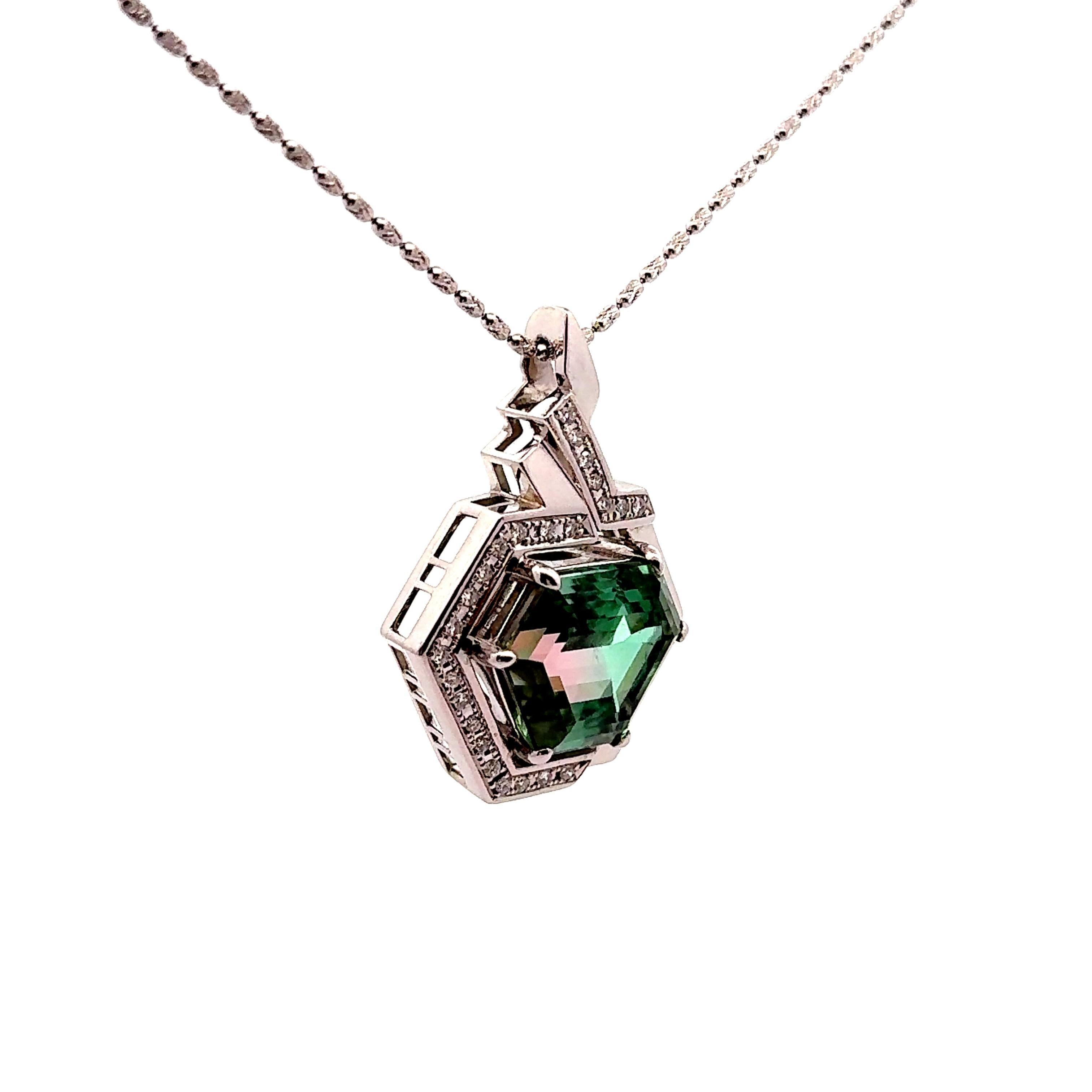 Ce pendentif présente en son centre une tourmaline de 23,32 carats taillée en hexagone, affichant une captivante teinte vert-rose. Fabriqué en platine, le design est contemporain et géométrique, avec des lignes épurées qui renforcent son attrait