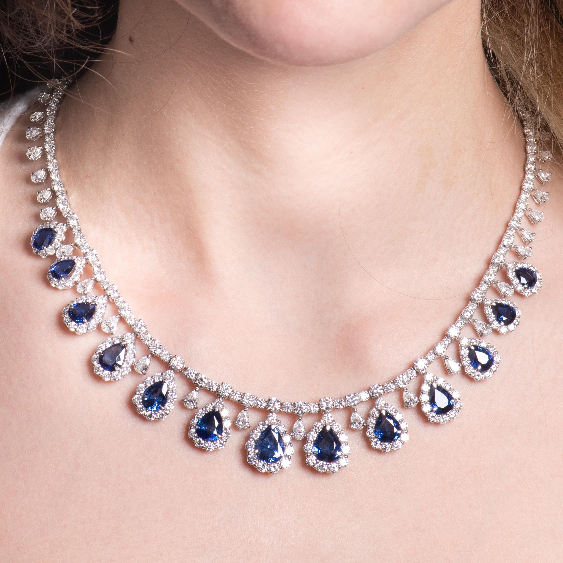 Dieses exquisite Collier besteht aus 23,38 ct Gesamtgewicht in birnenförmigen, satt königsblauen Saphiren, die von runden und birnenförmigen Diamanten umgeben sind, mit einem Gesamtgewicht von 28,34 ct. Die Diamanten wickeln sich um die gesamte