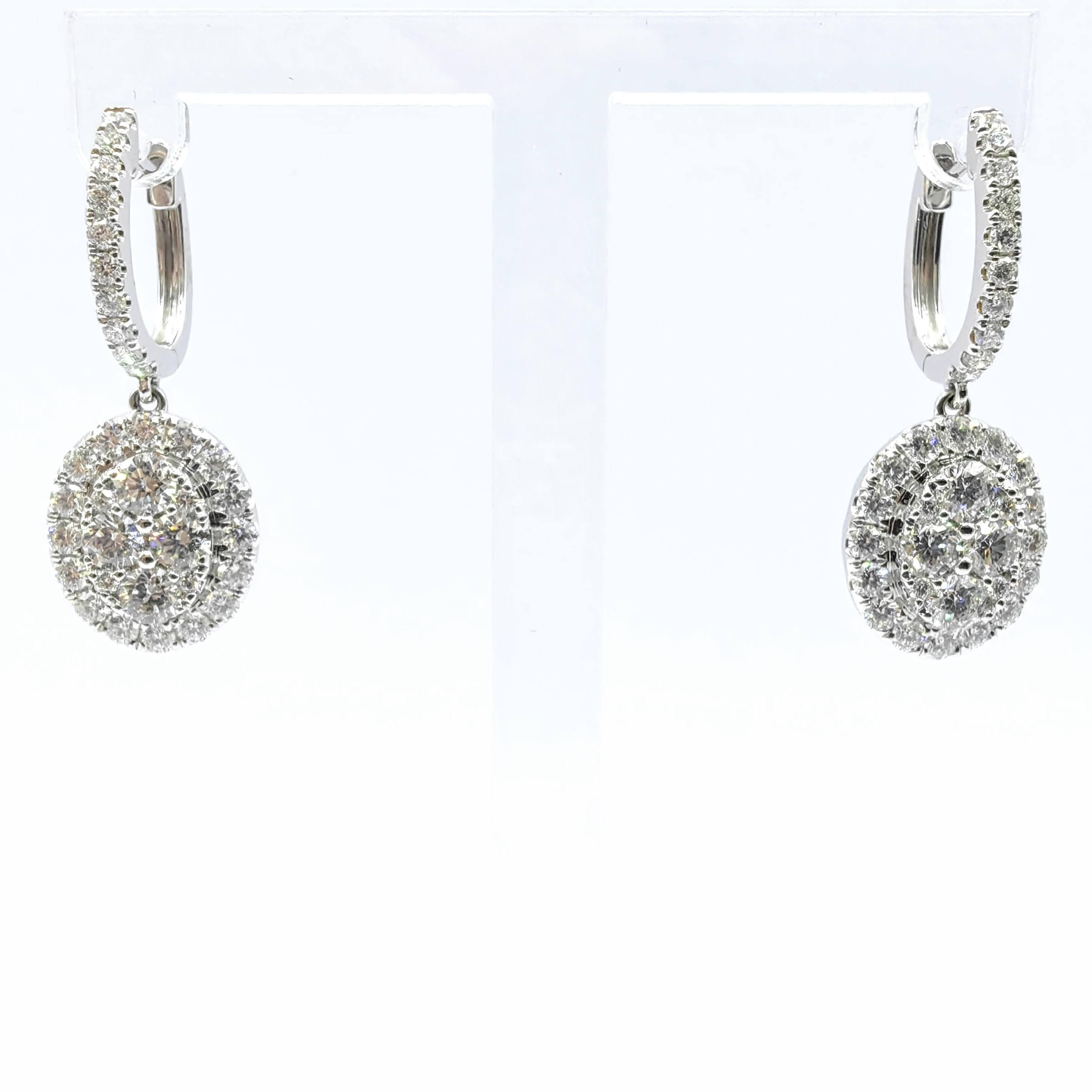 Step into timeless elegance with these captivating Oval Cluster Illusion Halo Diamond Drop Earrings, masterfully crafted in 18K white gold. Showcasing a dazzling array of round brilliant cut diamonds totaling approximately 2.334 carats, these