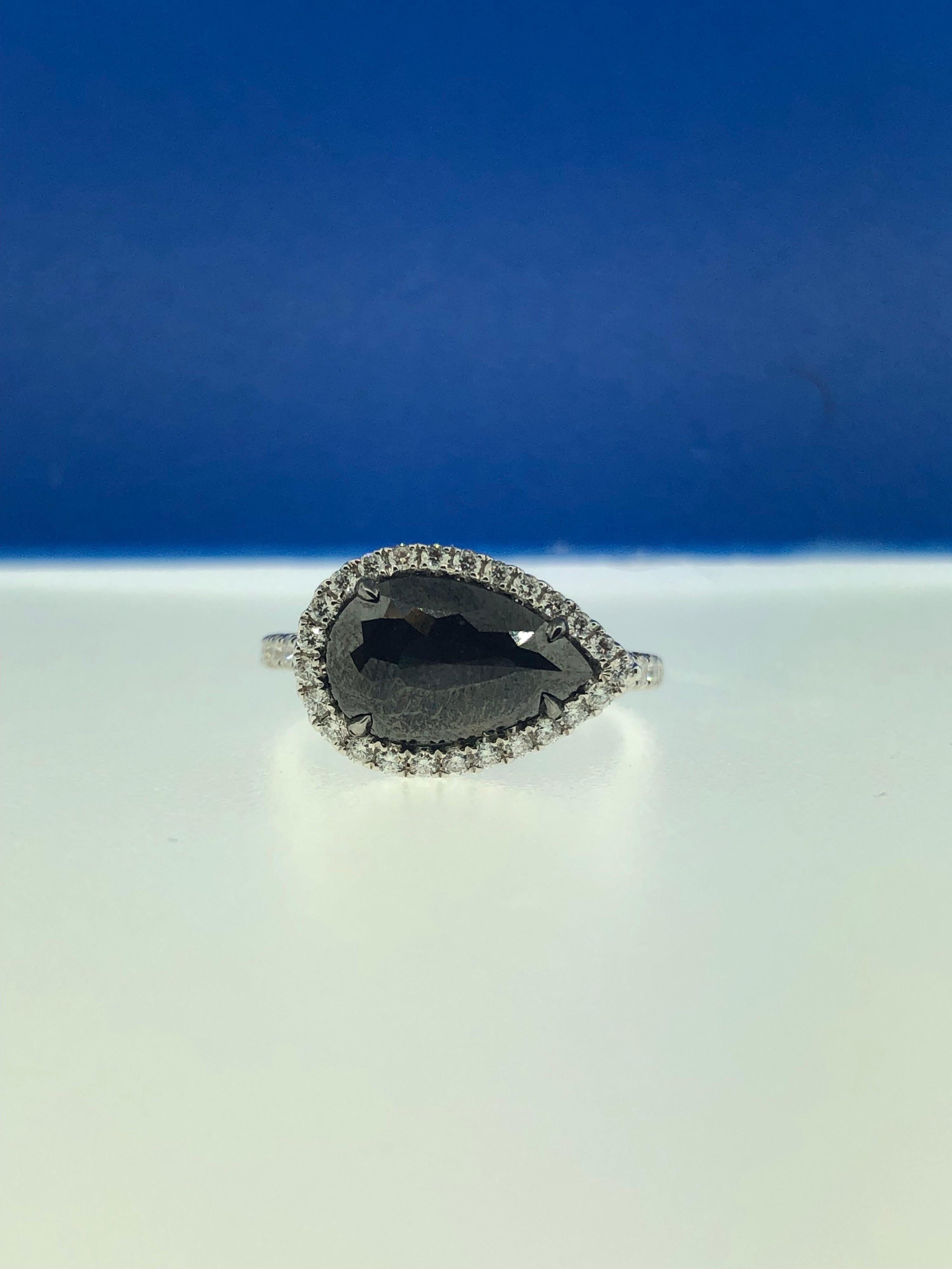 This stunning ring showcases a beautiful 2.34 carat rose cut pear shape black diamond with a white diamond halo set in 18 karat white gold. 
Total diamond weight (not including center stone) = 0.44 carats. Ring size is 6 1/2.
