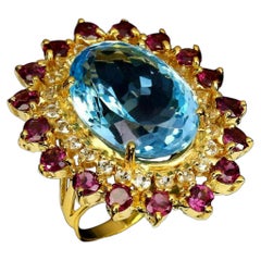 23.46 Carat Blue Topaz  
Garnet Ring 14 Karat Yellow Gold