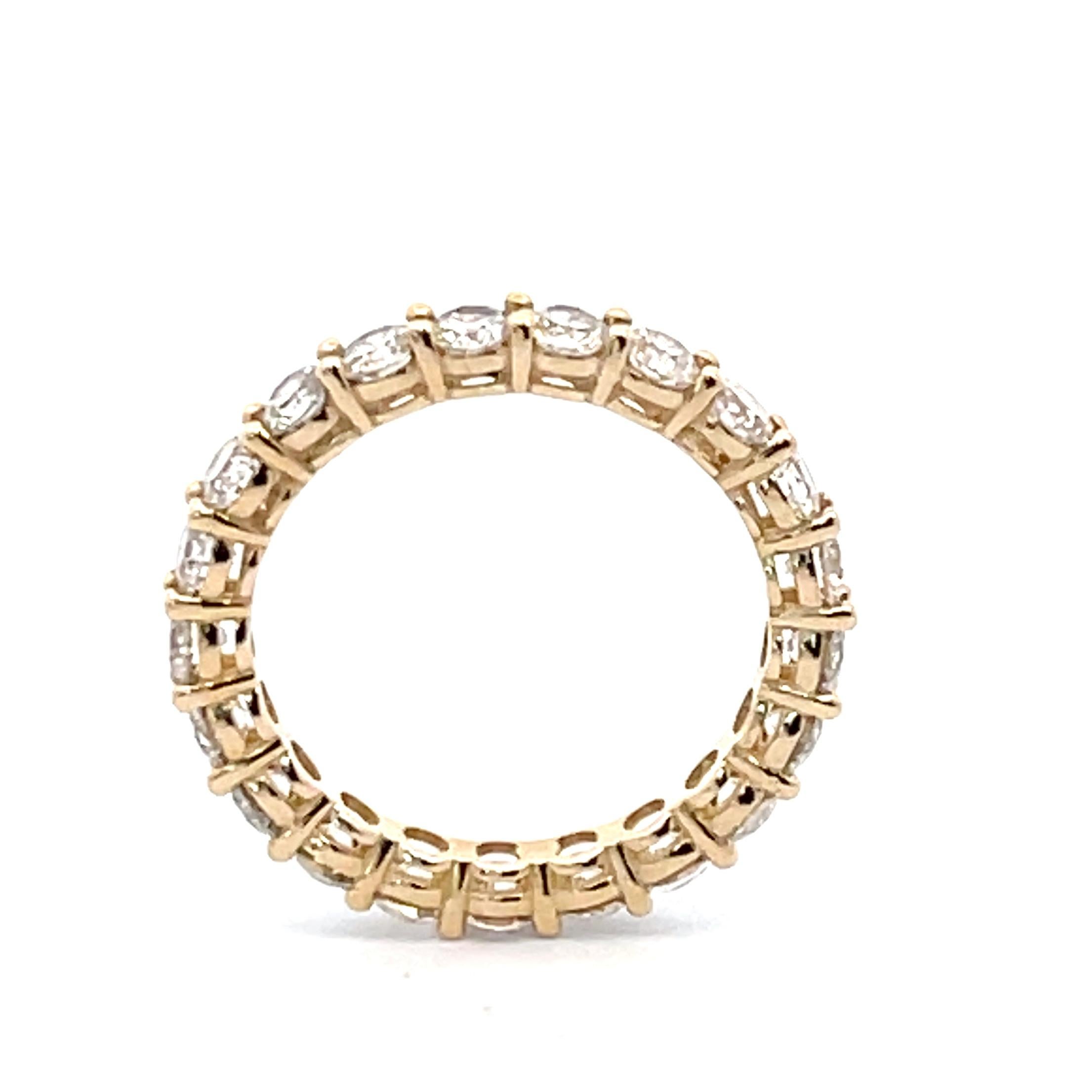 Treat yourself to a classic, timeless piece of jewelry with this 2.35 carat round brilliant cut diamond eternity wedding band in 14K yellow gold. This stunning eternity band ring is crafted with 21 round diamonds in a common prong setting, and its